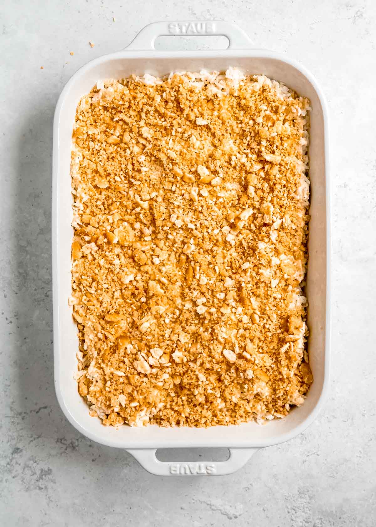 cracker crumb topping after being added to baking dish with poppy seed chicken