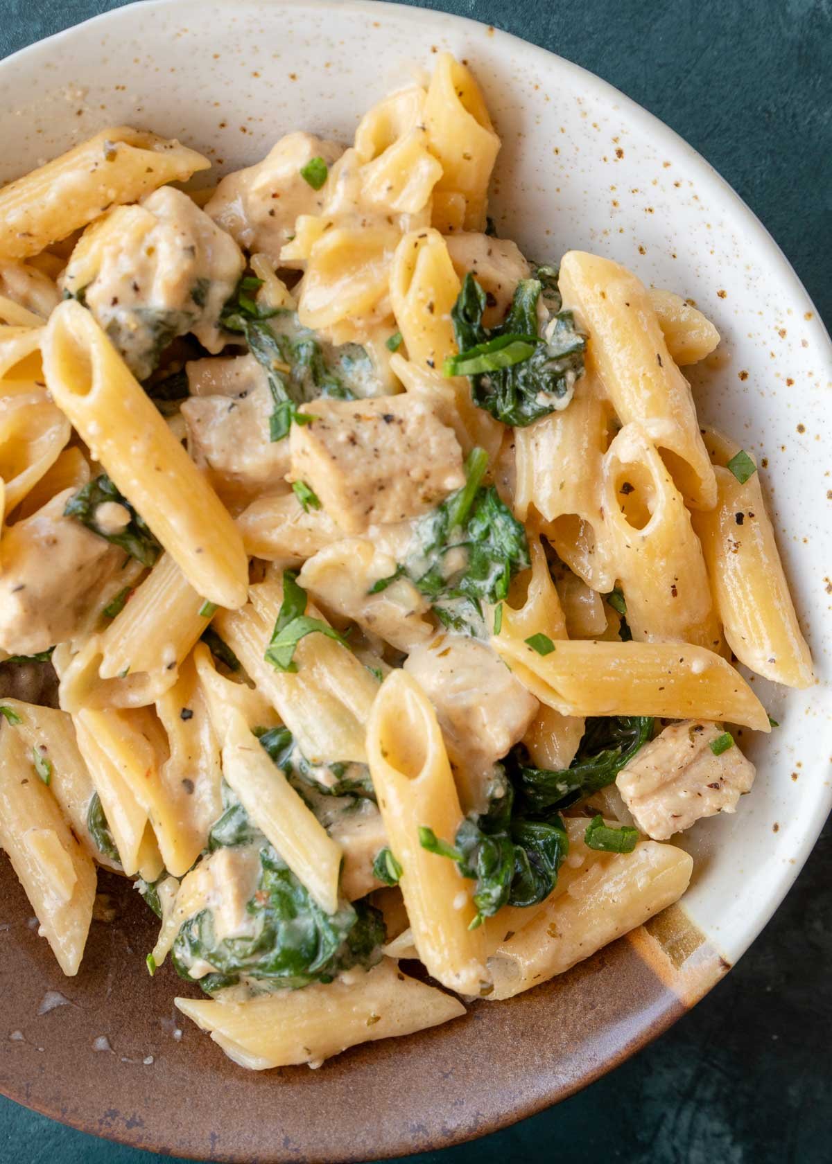 overhead shot of penne with chicken and spinach