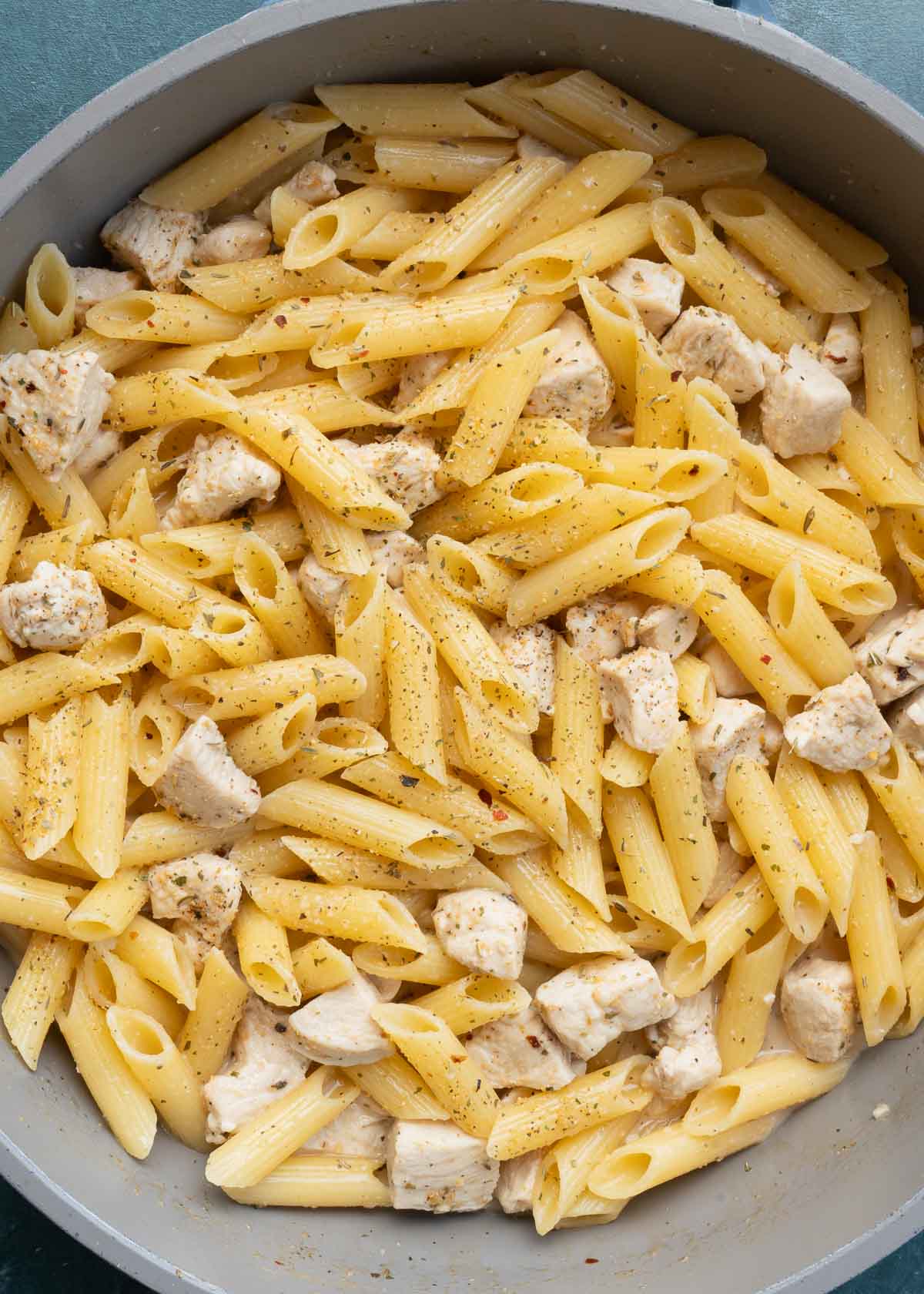 cooked penne and chicken in skillet