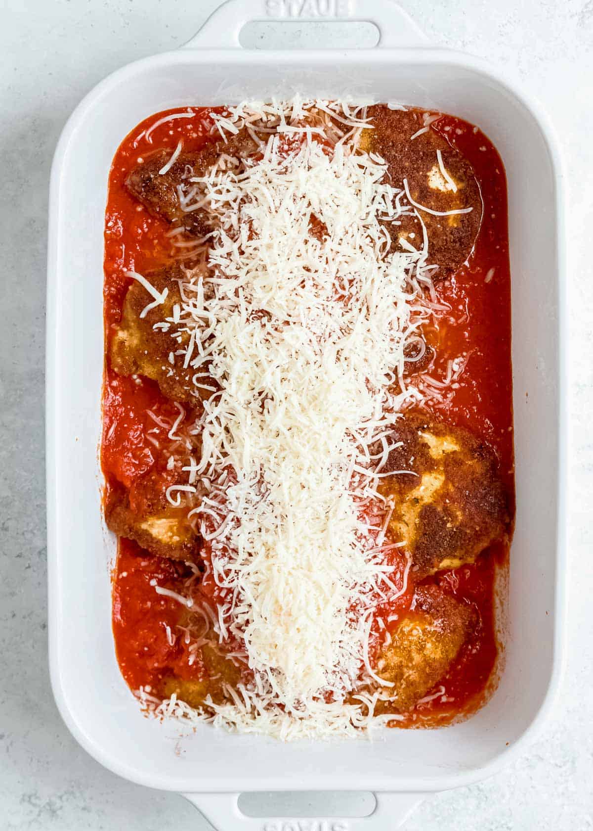 chicken parmesan in baking dish prior to baking 