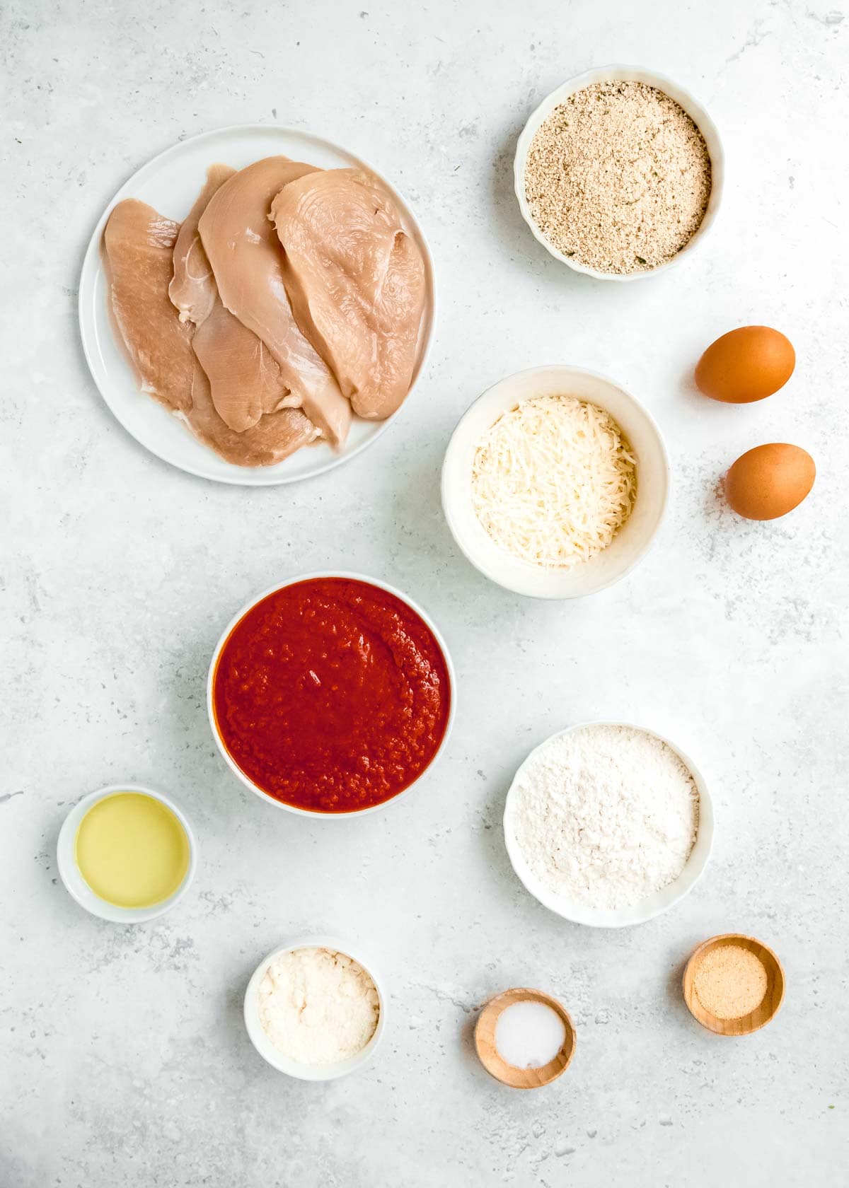 chicken parmesan ingredients on a white table