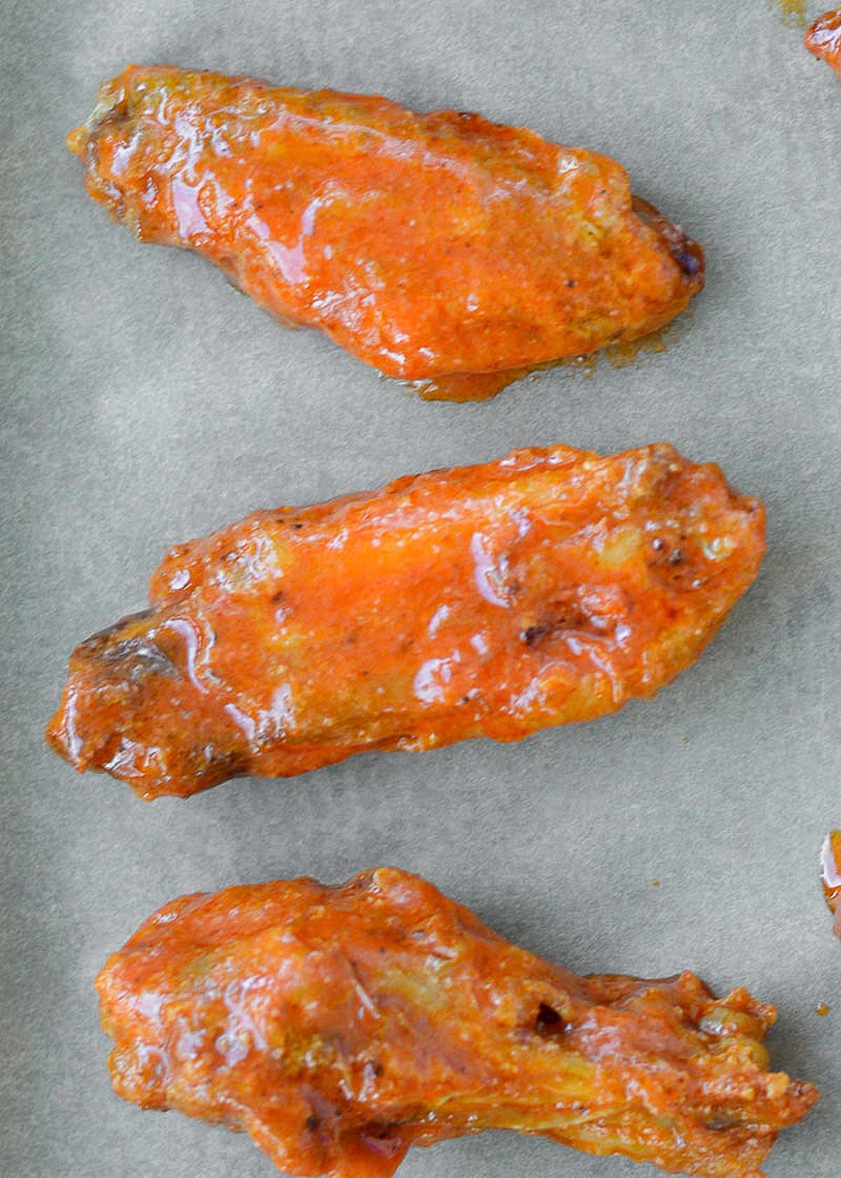 closeup shot of crispy air fryer chicken wings coated in delicious buffalo sauce