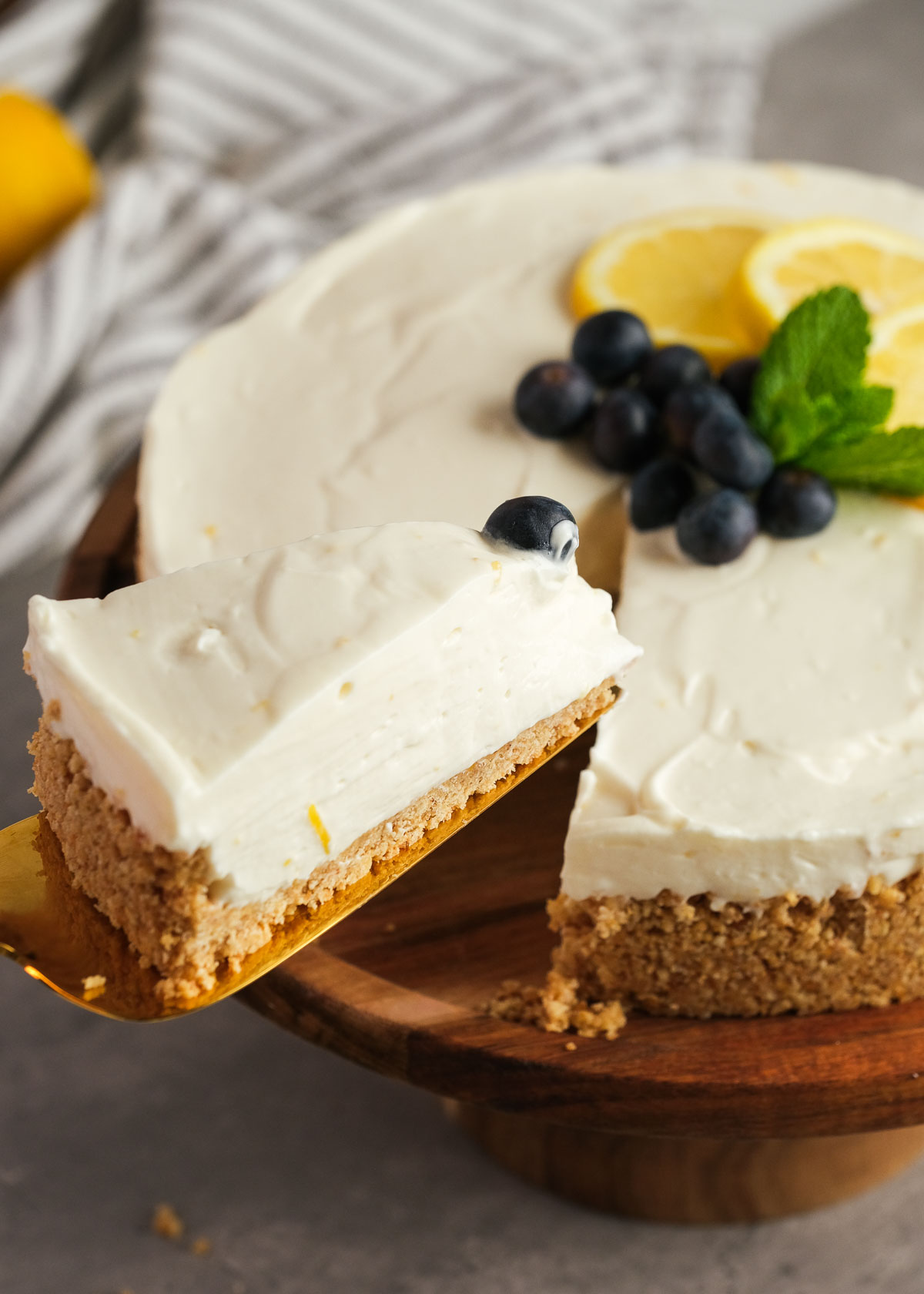 a serving spatula grabbing a slice of easy lemon cheesecake topped with blueberries