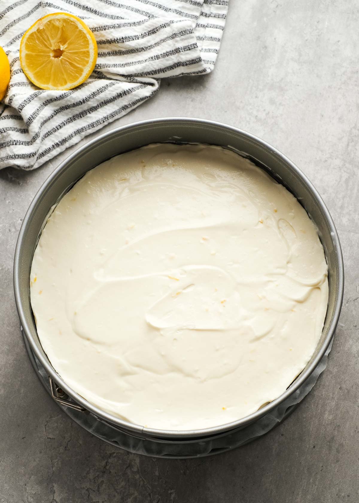 lemon cheesecake mixture smoothed over a graham cracker crust in a springform pan