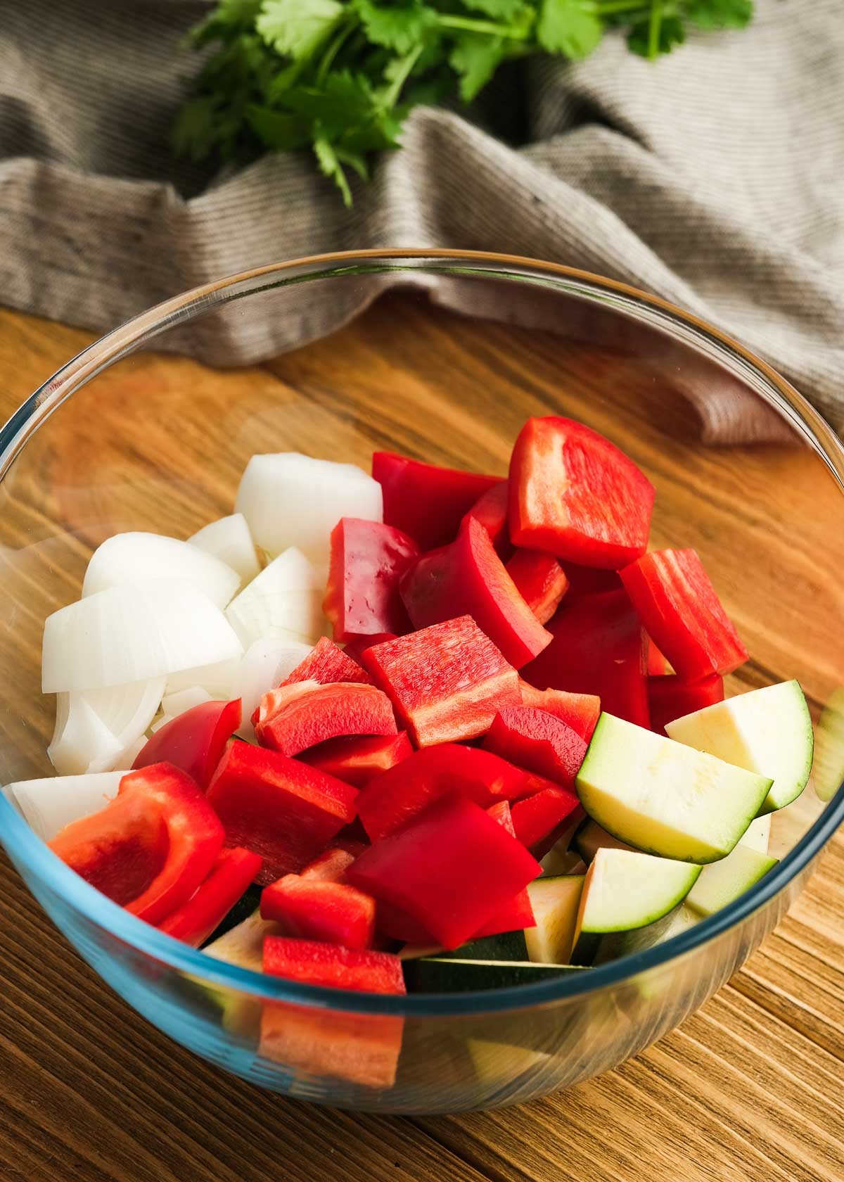 chopped red bell pepper, zucchini, and onion in a glass bowl