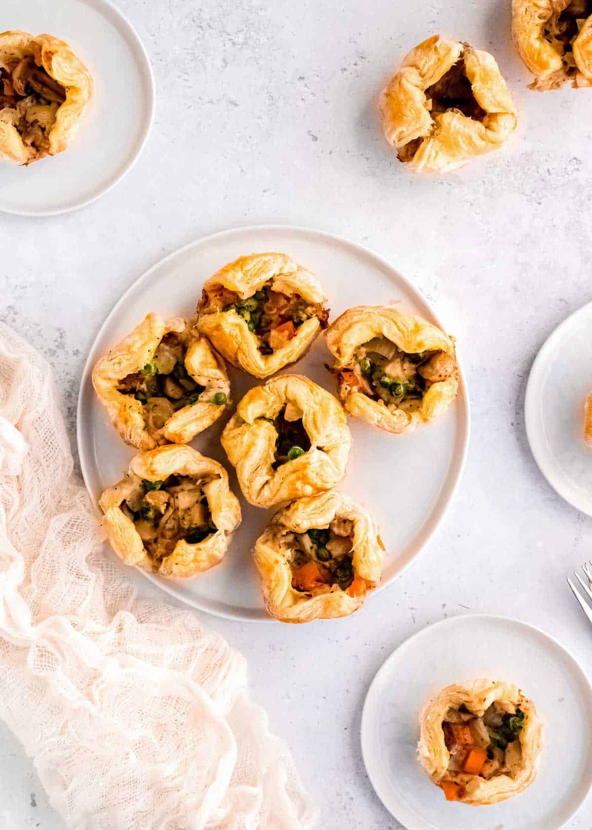 overhead shot showing a platter of mini chicken pot pies with puff pastry on a table