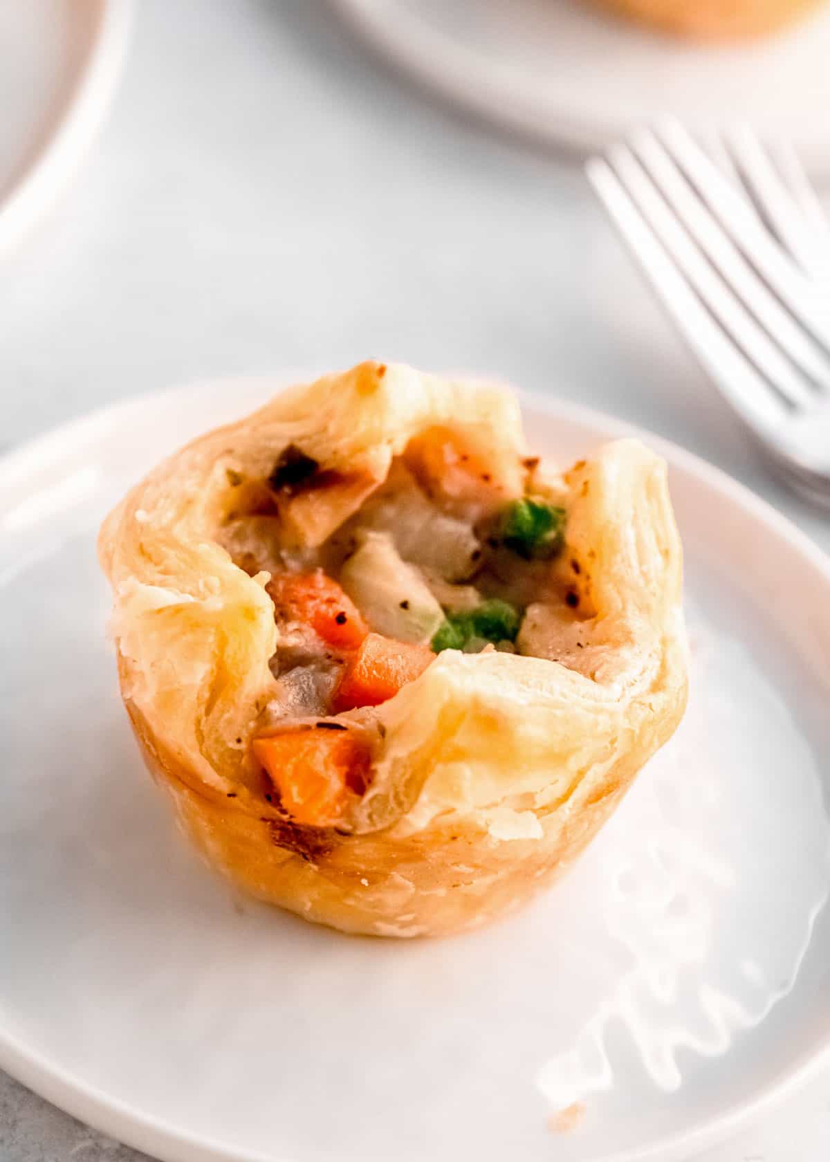 one mini chicken pot pie made with puff pastry on a white plate