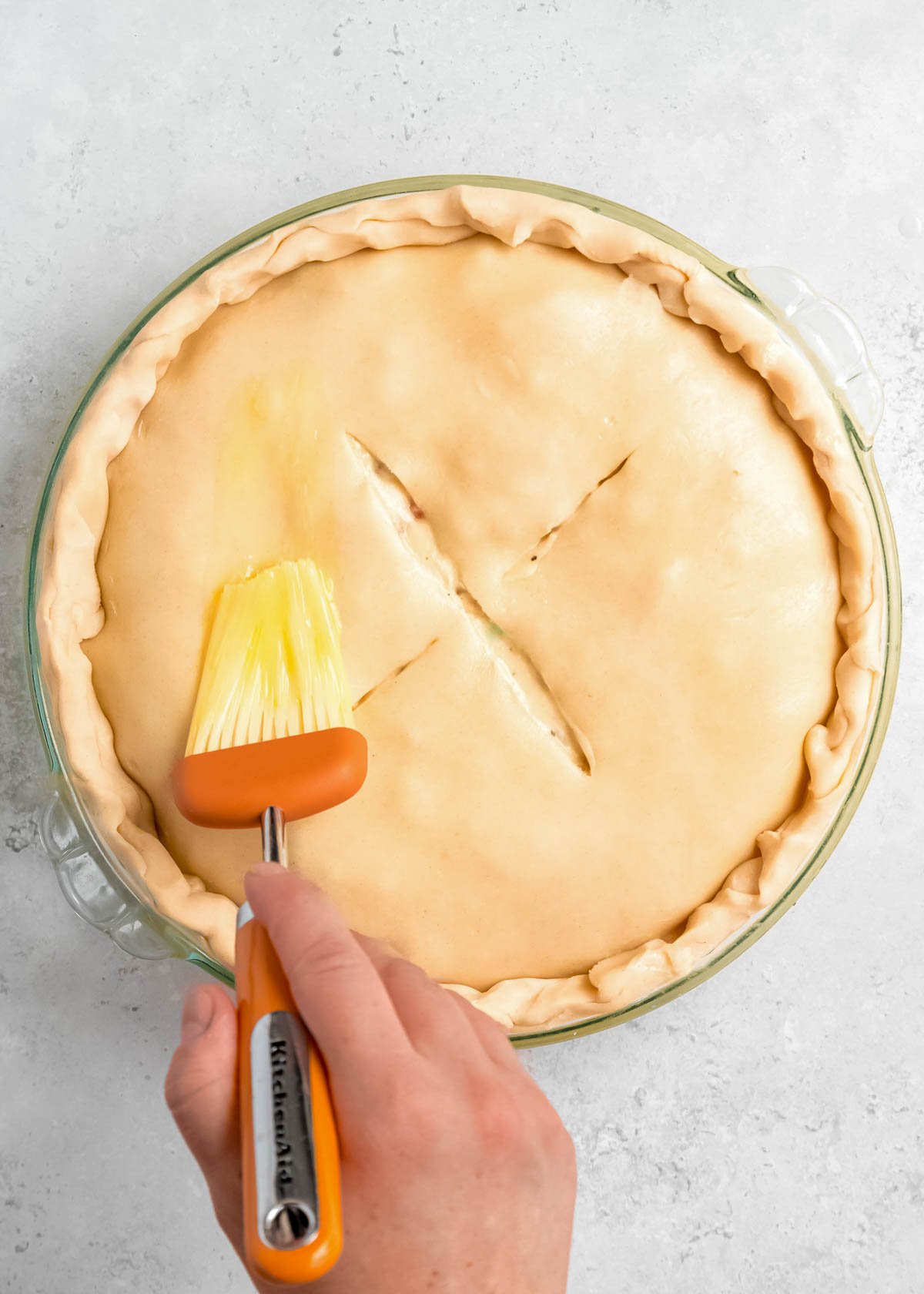 chicken pot pie being brushed with egg