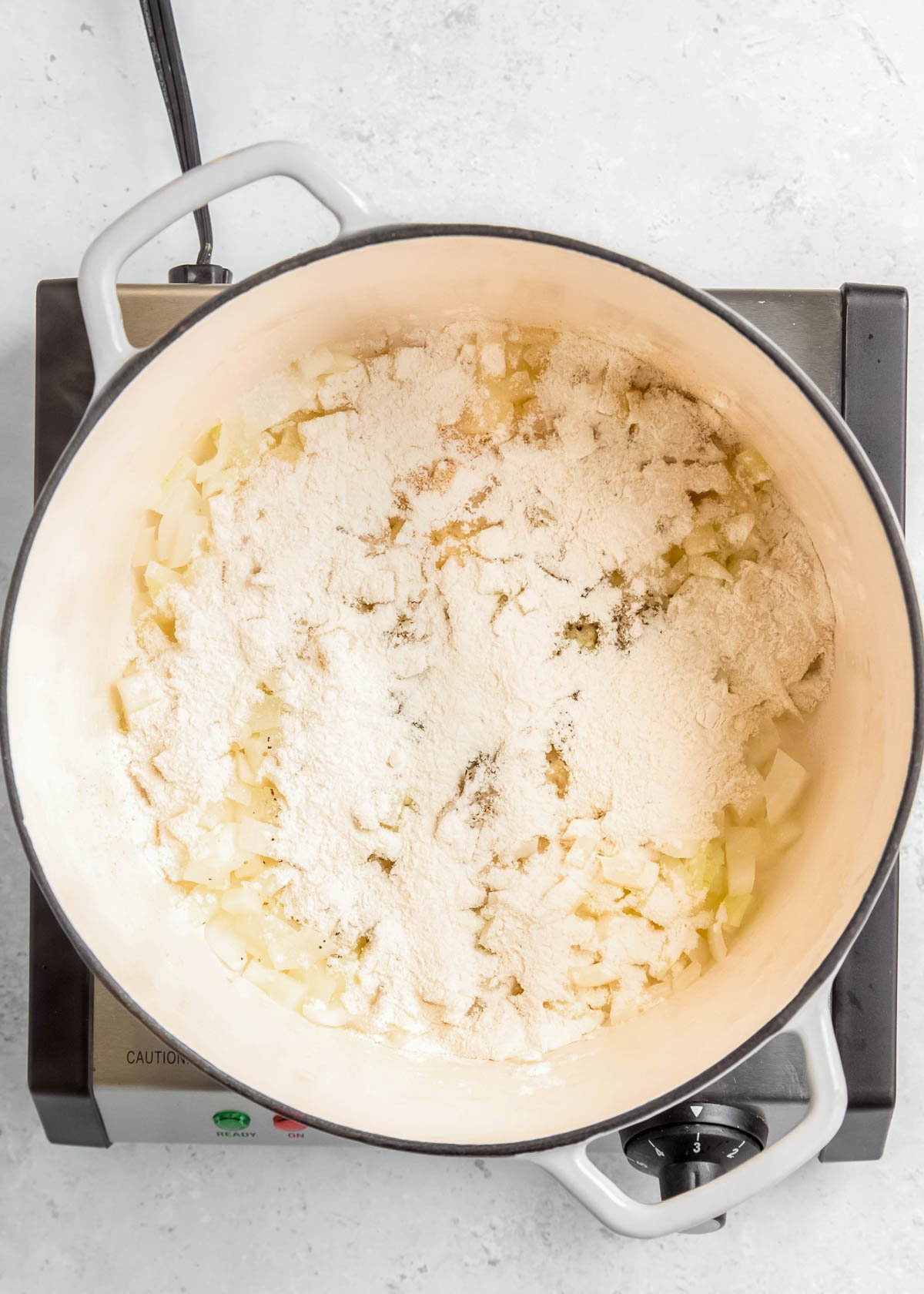 overhead image of flour being added to pan