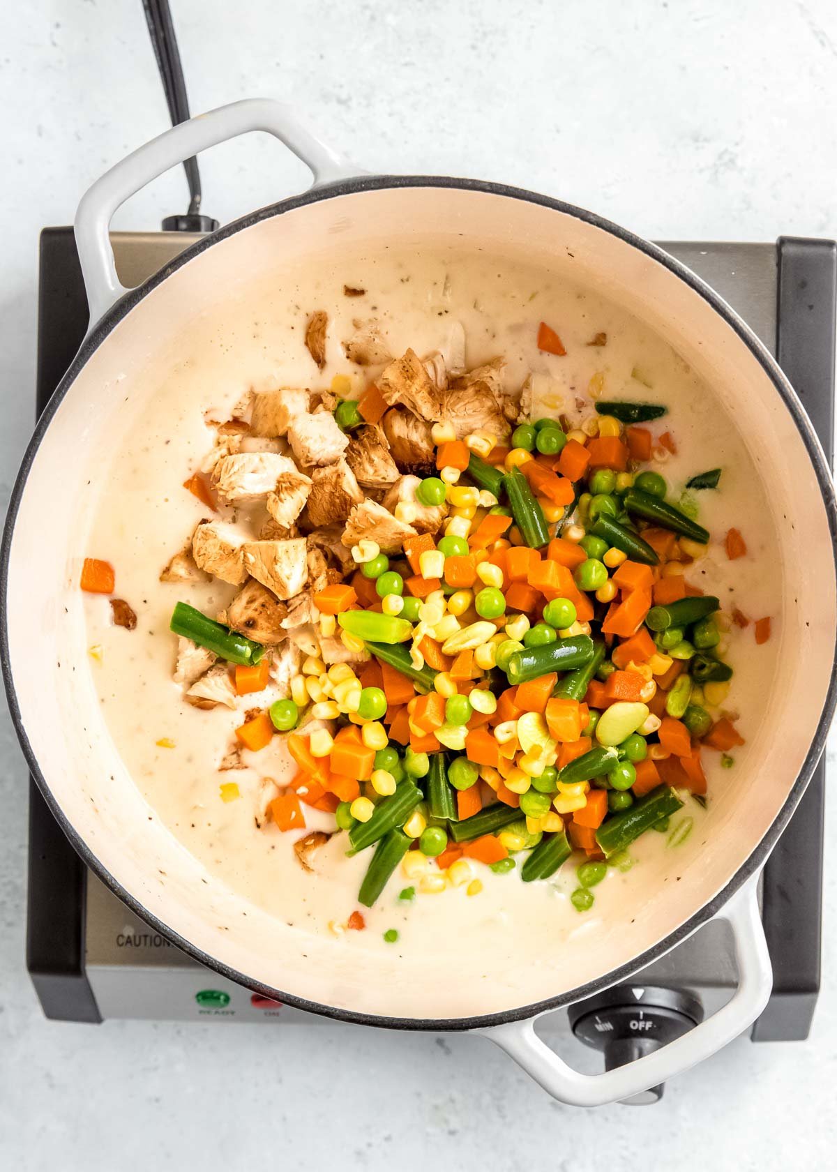 veggies being added to chicken pot pie mix