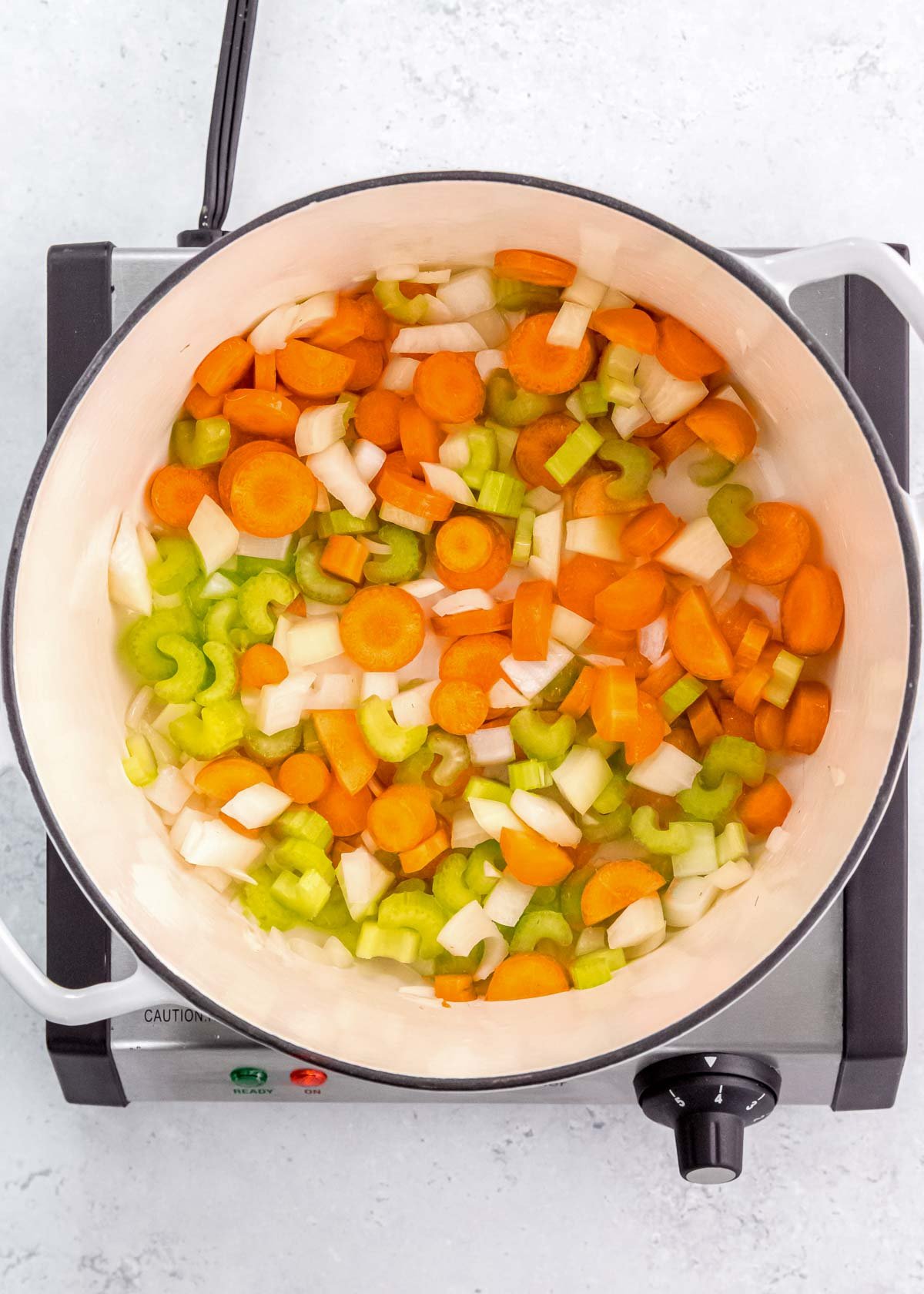 carrots, celery, and onion sautéing in a large dutch oven