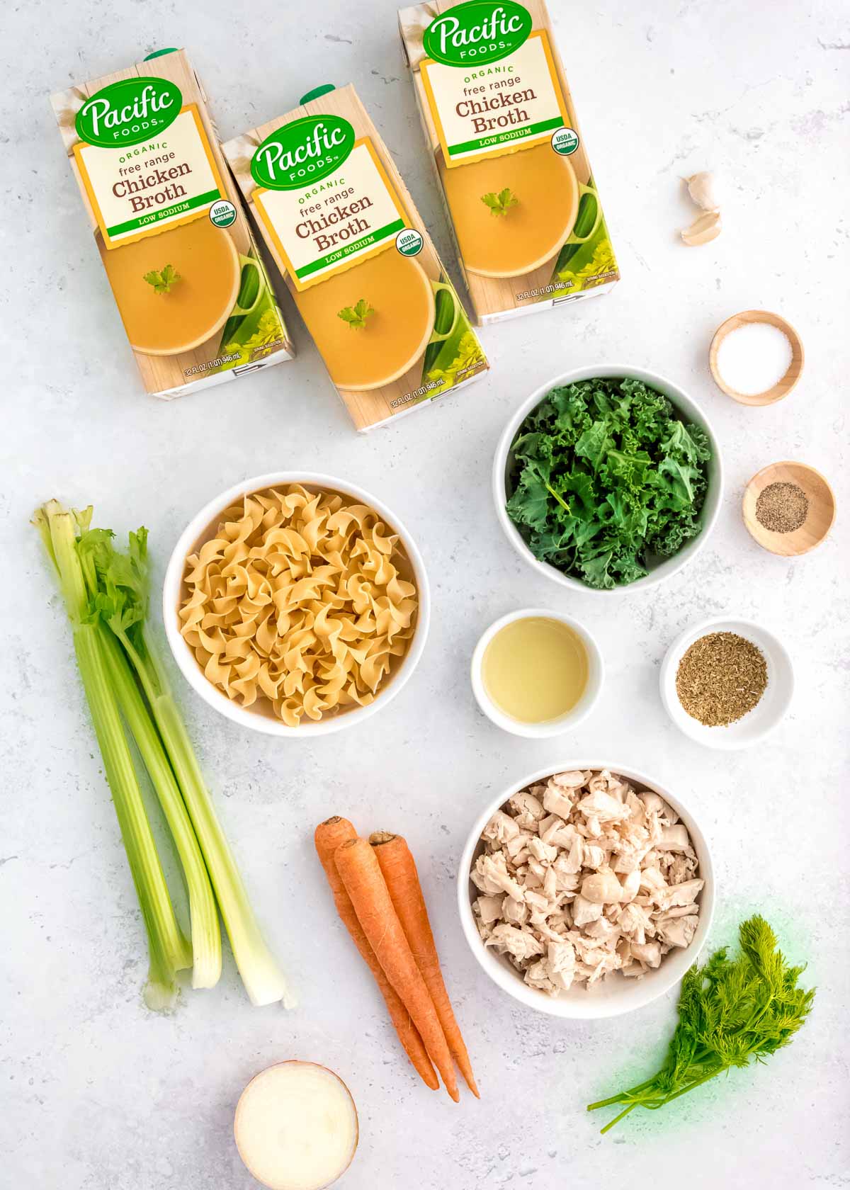 all ingredients needed for chicken and egg noodle soup on a white background