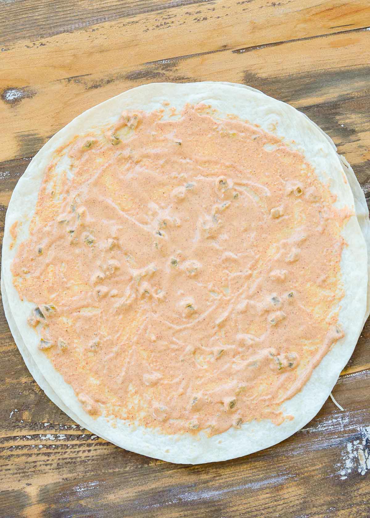 creamy jalapeno sauce spread all over a large tortilla