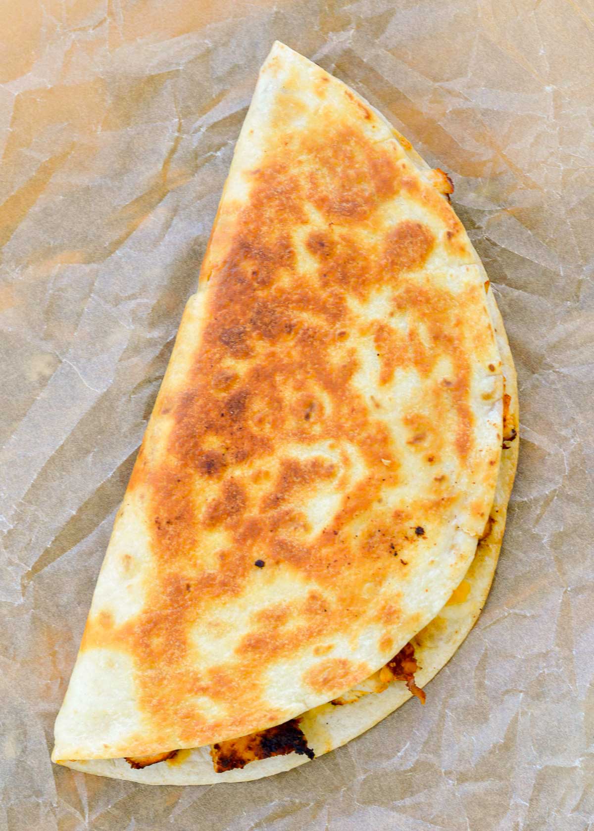 a golden brown quesadilla filled with juicy chicken, creamy jalapeno sauce, and melty cheese