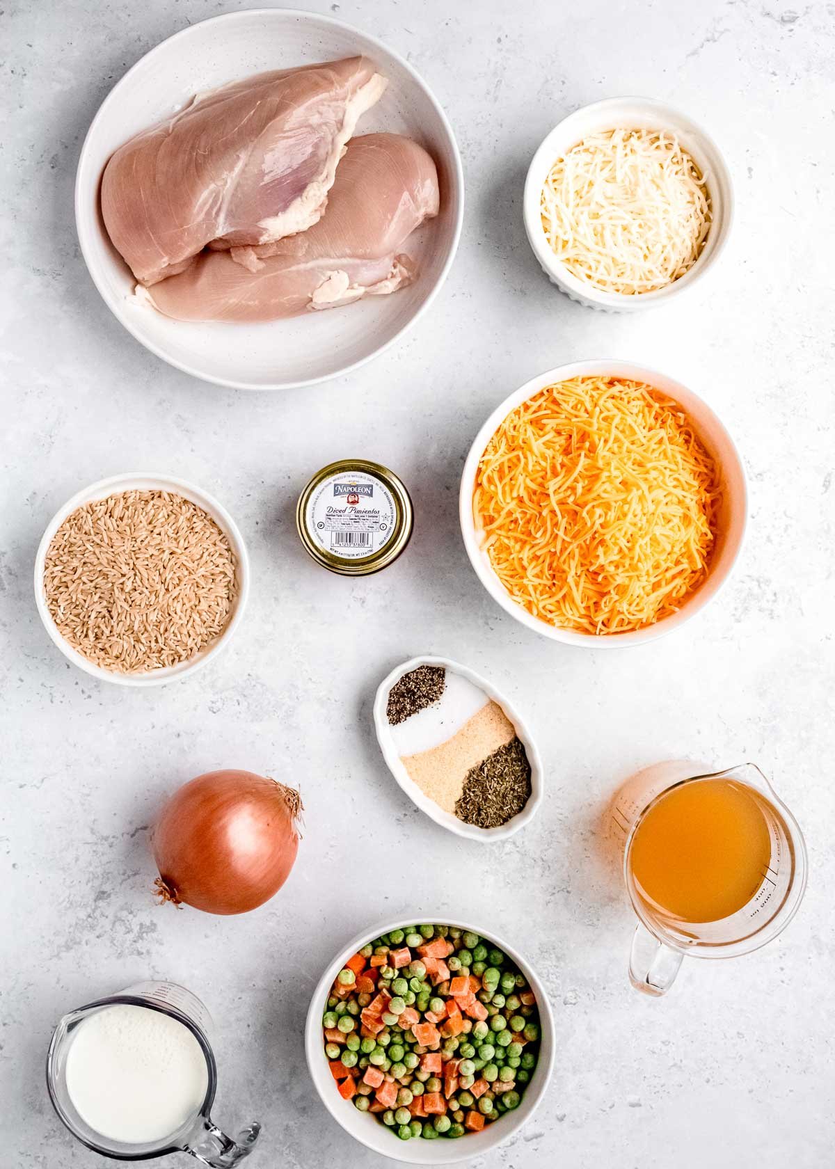 all individual ingredients for crockpot chicken and rice on a white background