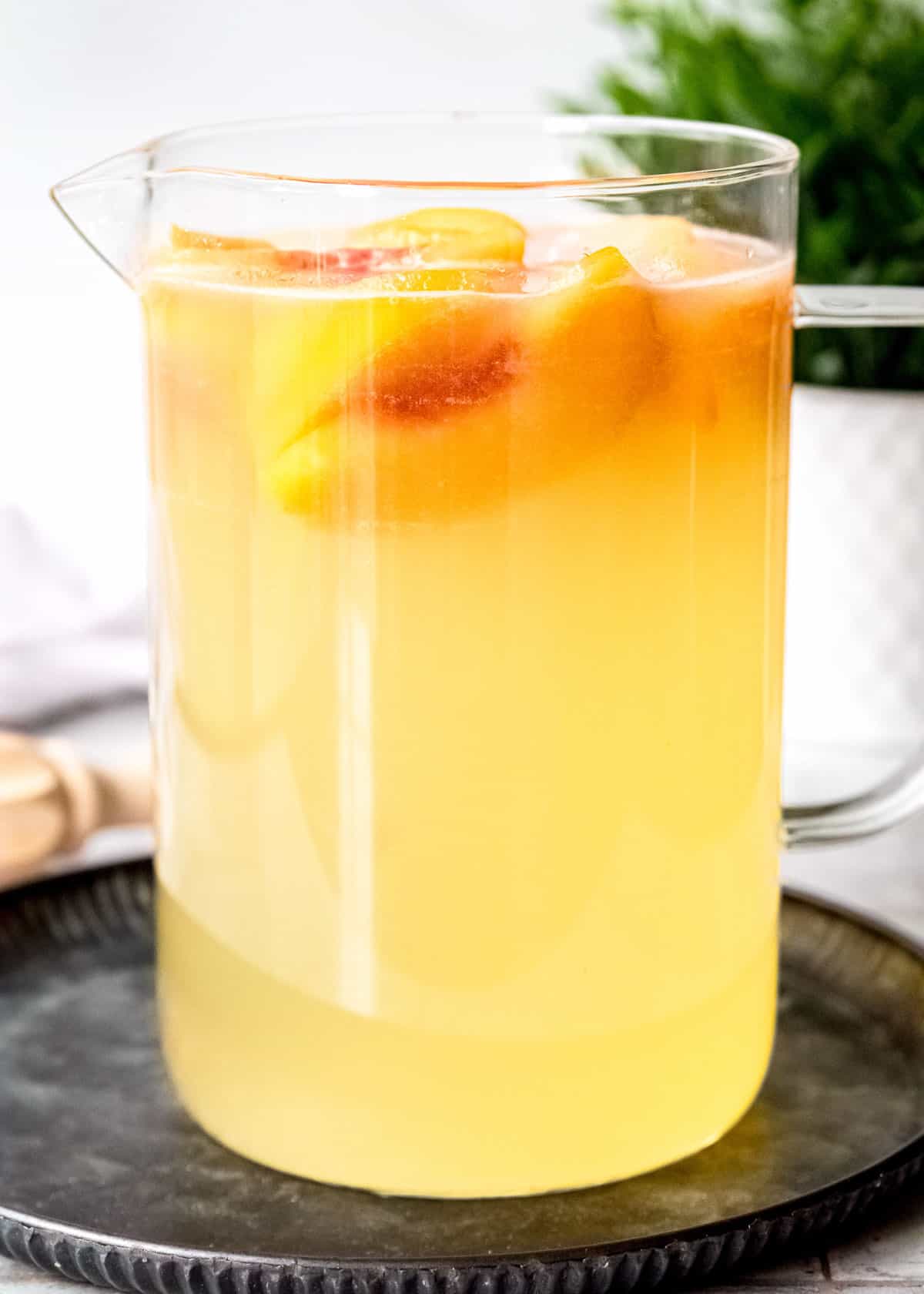 a large pitcher of peach lemonade with peach schnapps and bourbon