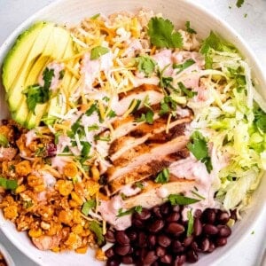 overhead shot showing a packed burrito bowl full of southwestern chicken, brown rice, and Mexican street corn salad