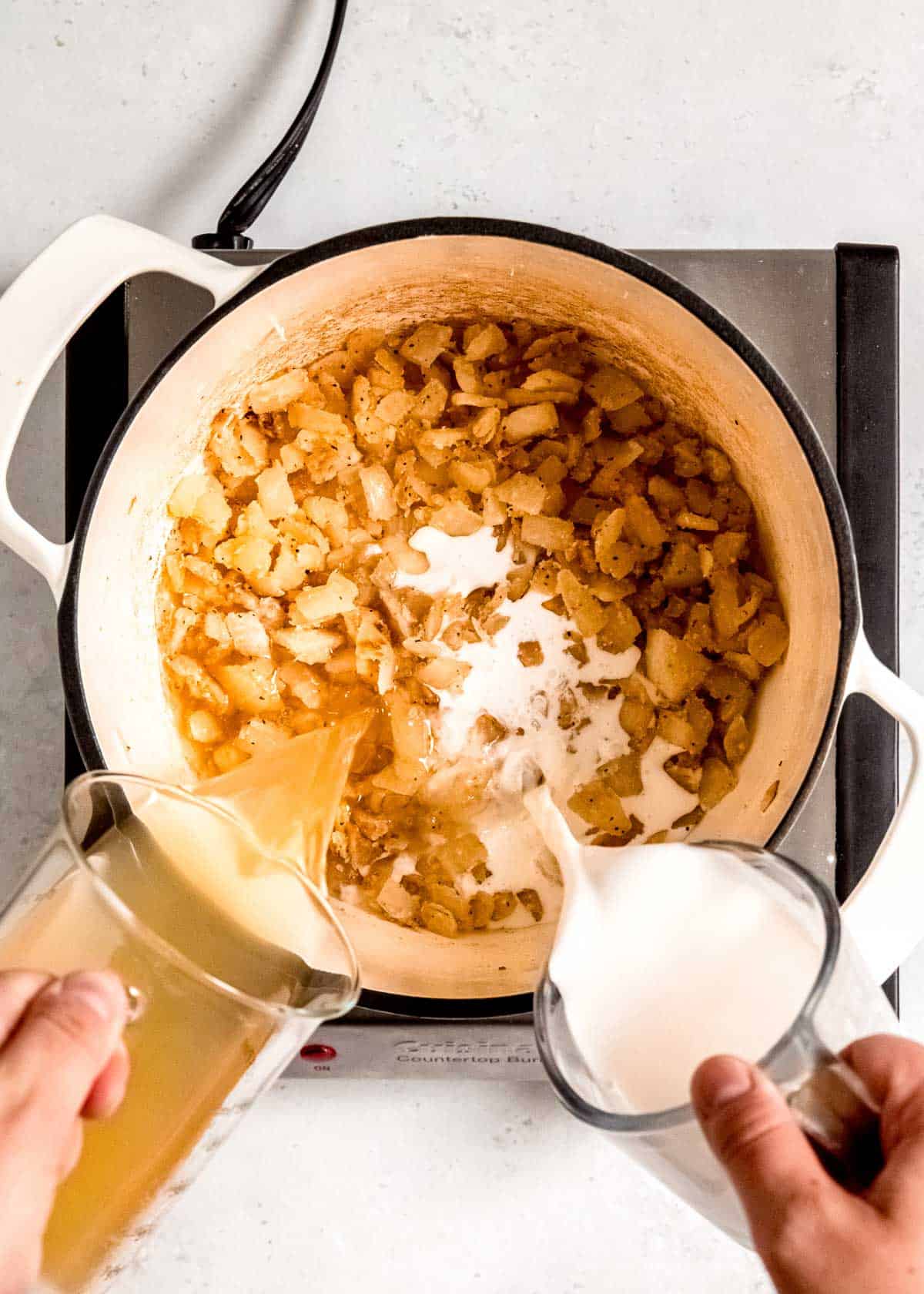 broth and half n half pouring into the pot to make a roux