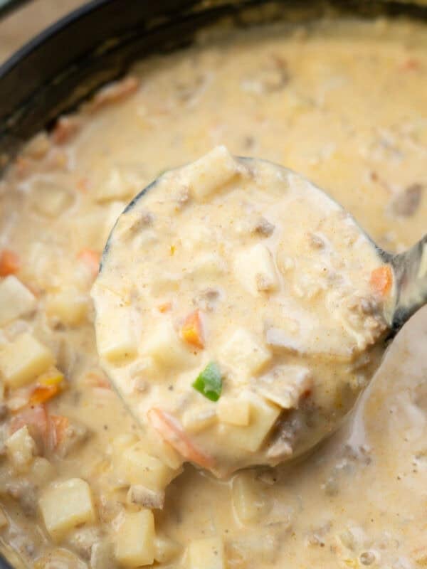 a ladle filled with creamy hamburger potato soup