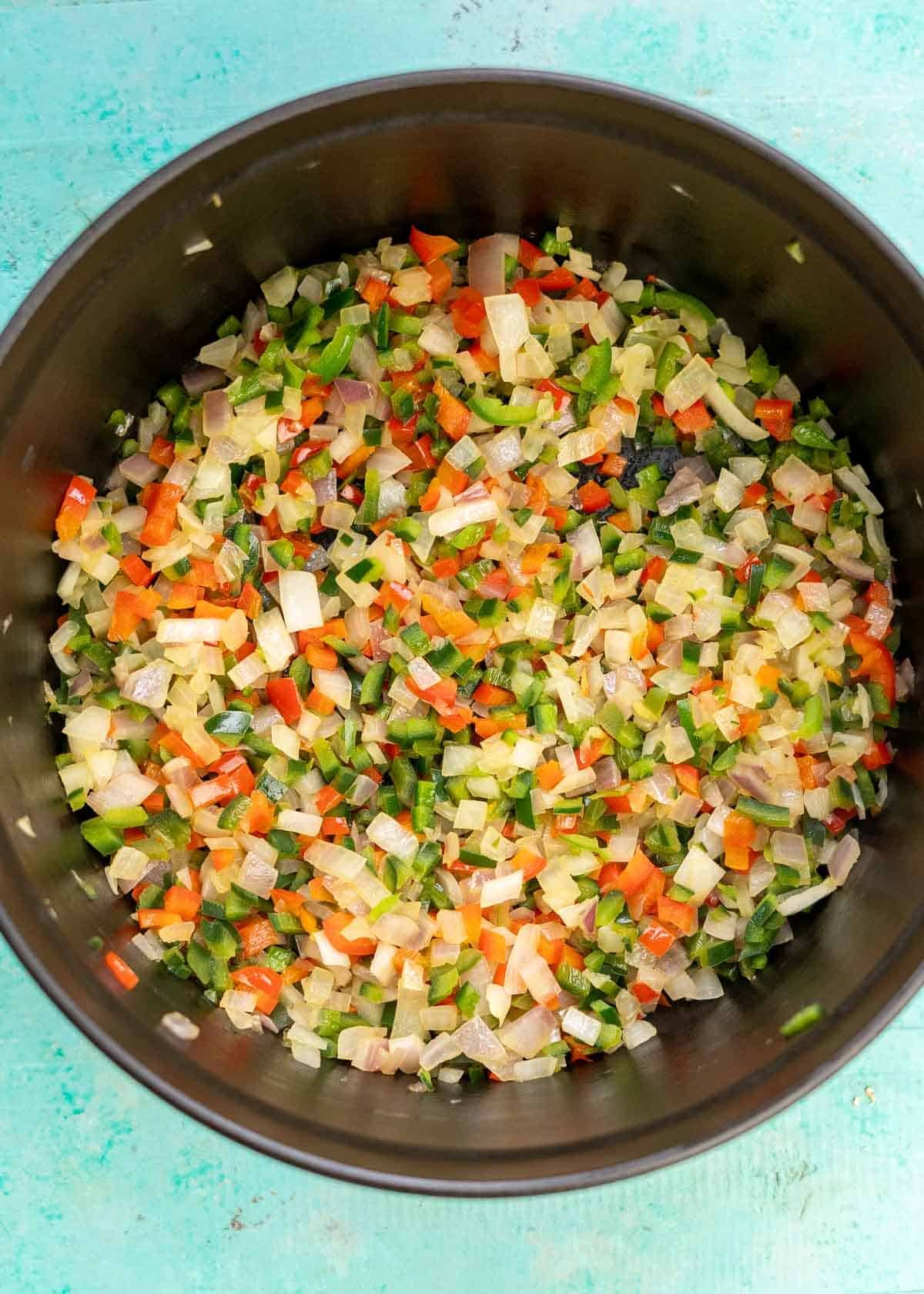 sauteed onions and peppers in a cast iron soup pot