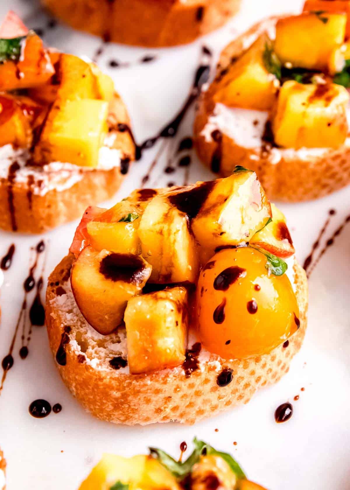 tomato and peach bruschetta with goat cheese and balsamic glaze