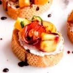 This amazing peach bruschetta is topped with a drizzle of balsamic glaze.