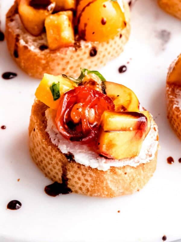 This amazing peach bruschetta is topped with a drizzle of balsamic glaze.