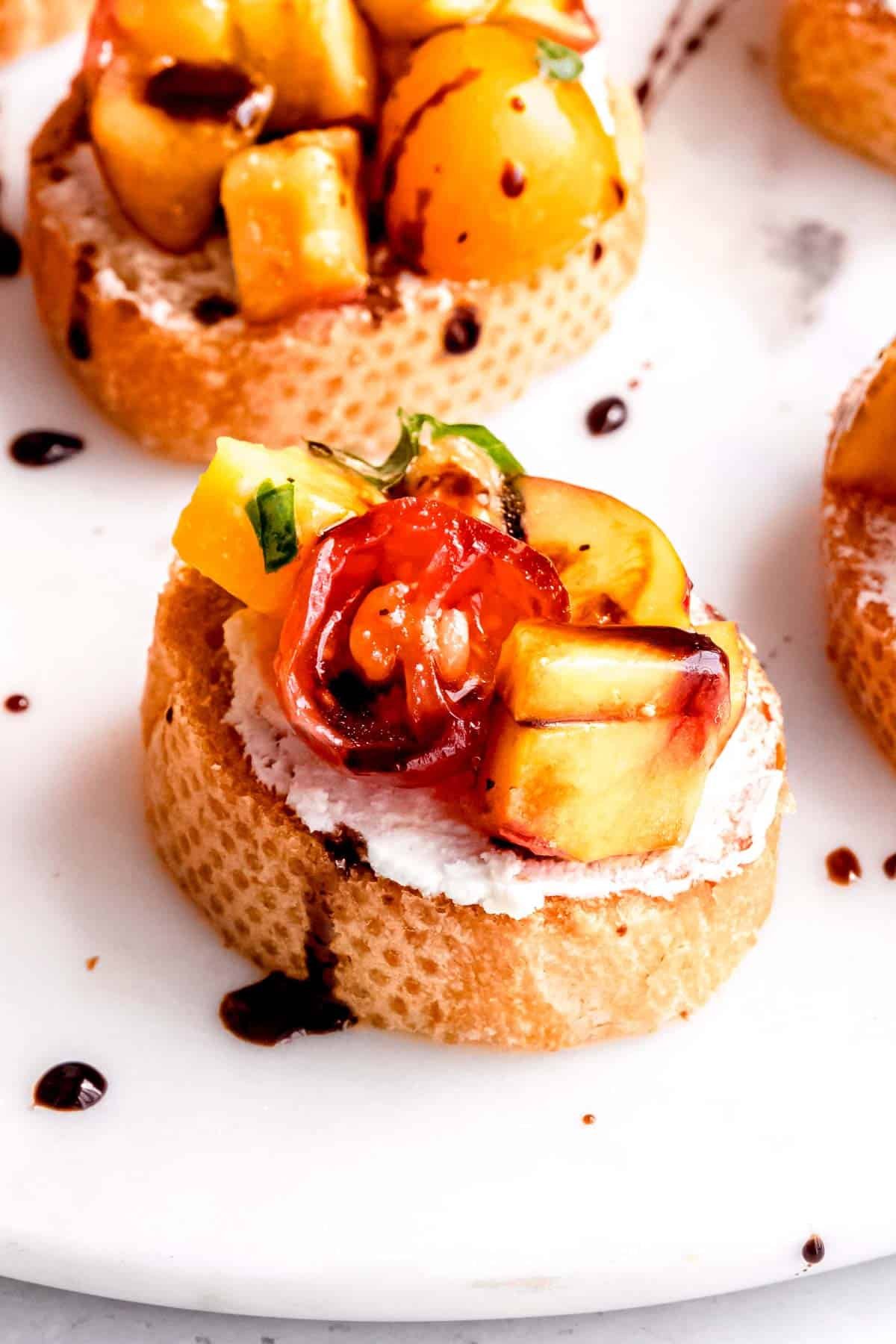 This amazing peach bruschetta is topped with a drizzle of balsamic glaze.