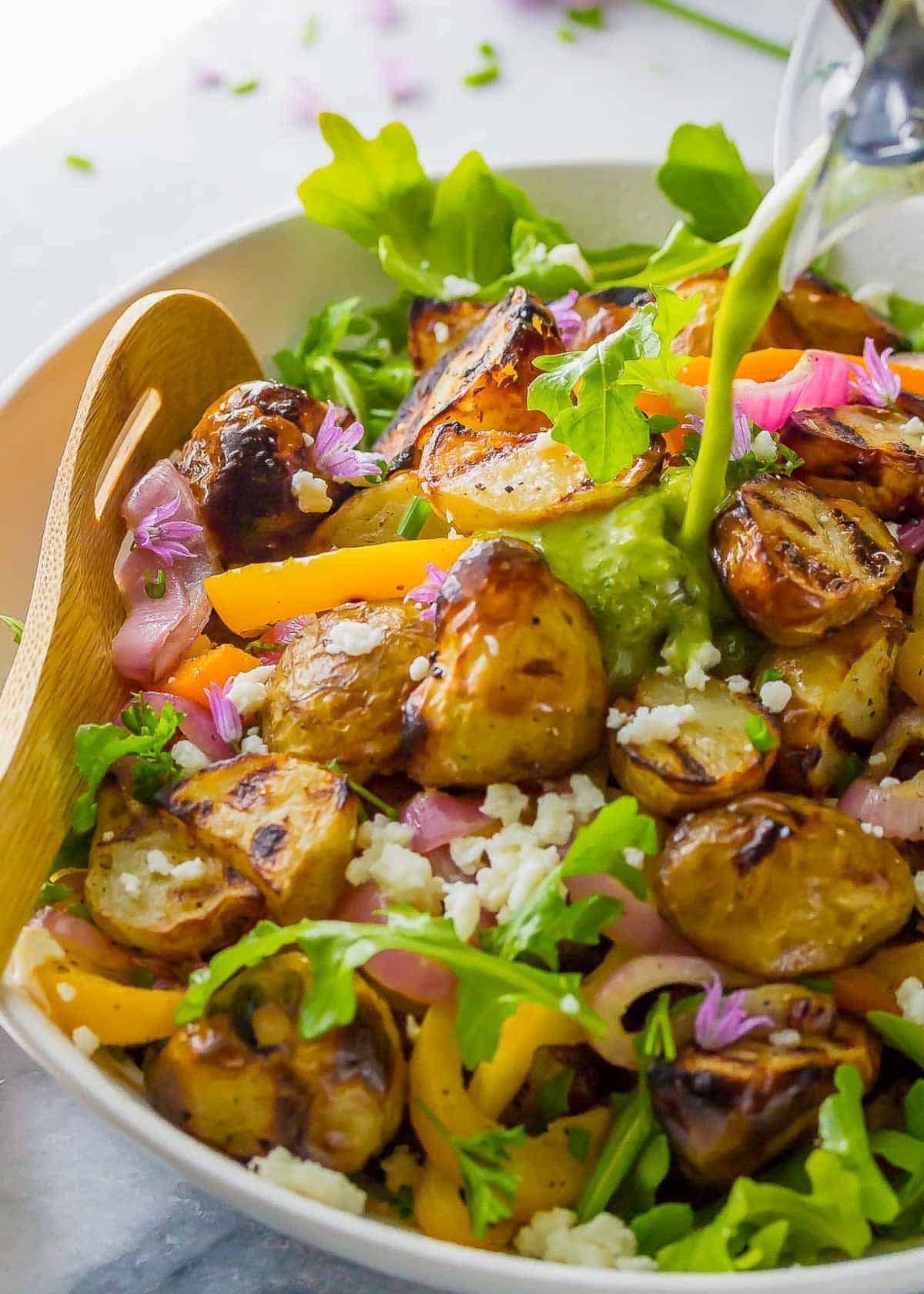 grilled vegetables over arugula and tossed with a lemon vinaigrette dressing in a white bowl