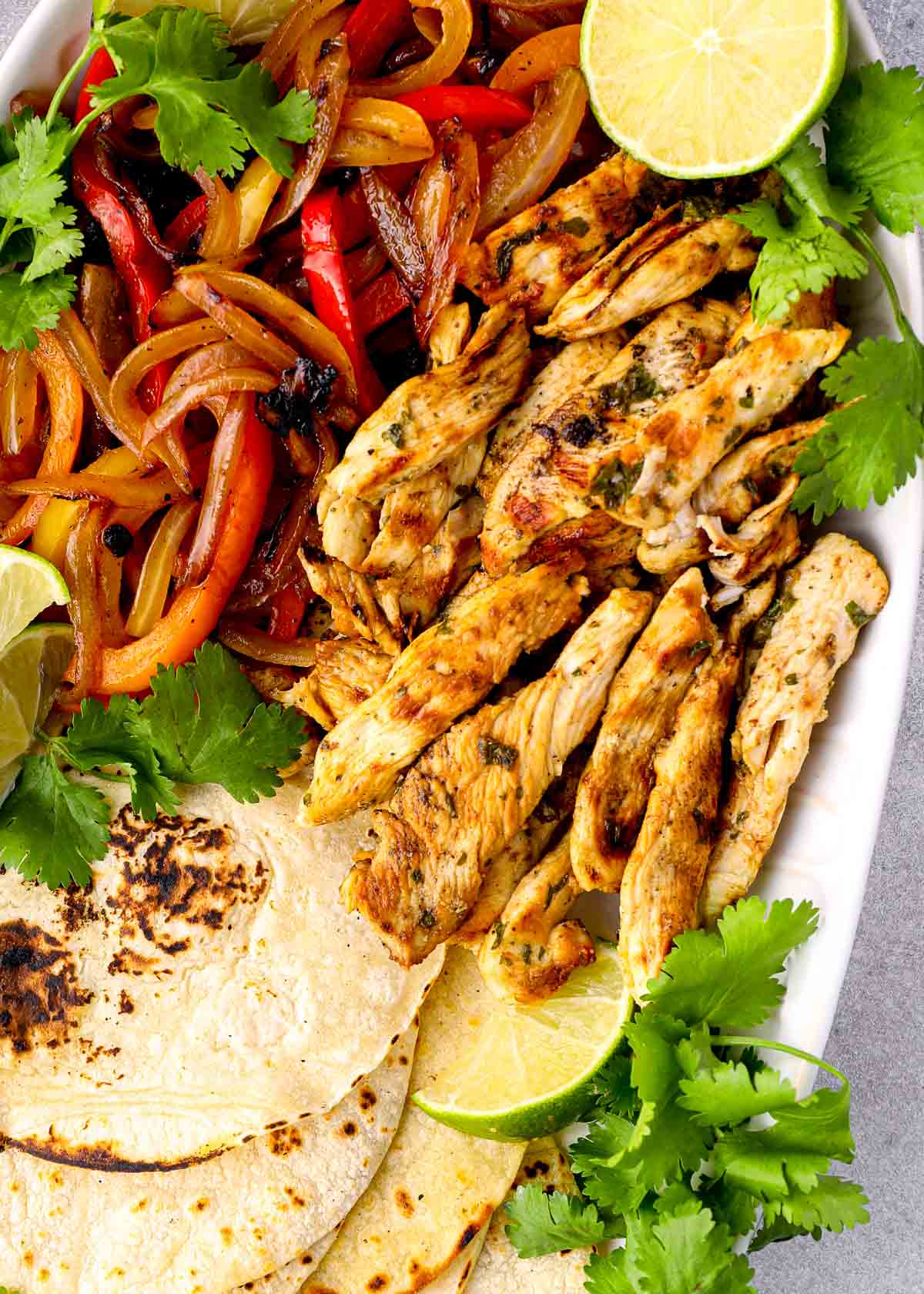 overhead shot showing a chicken fajitas on a white platter