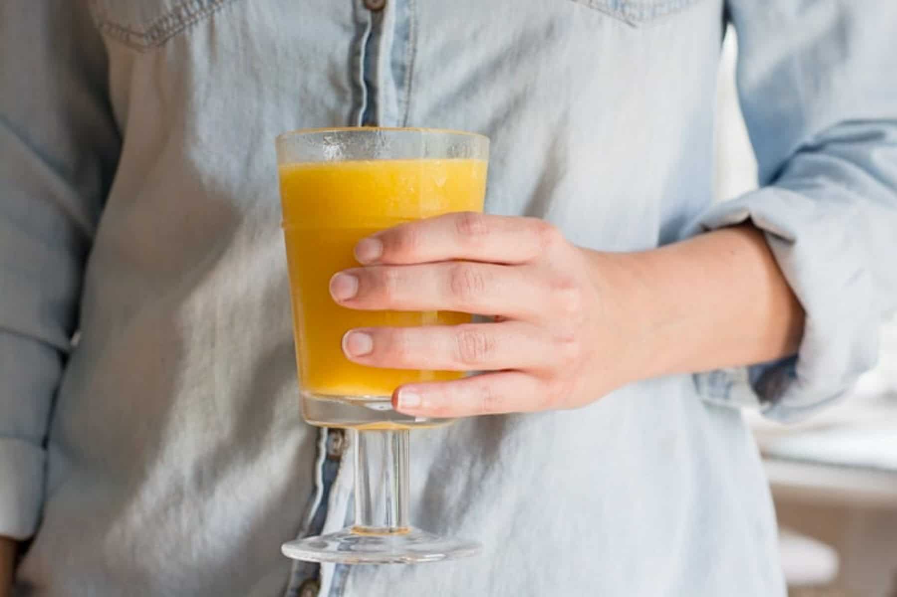 someone holding a glass filled with wine slushy