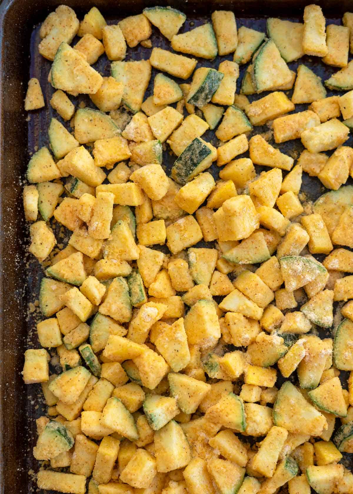 cornmeal coated zucchini and squash on a baking sheet