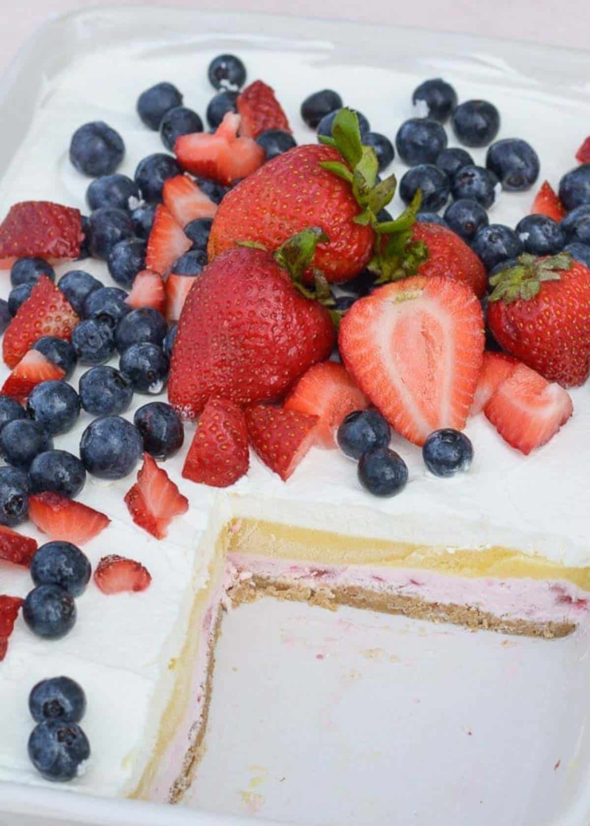overhead shot showing creamy layered cheesecake bars topped with fresh berries