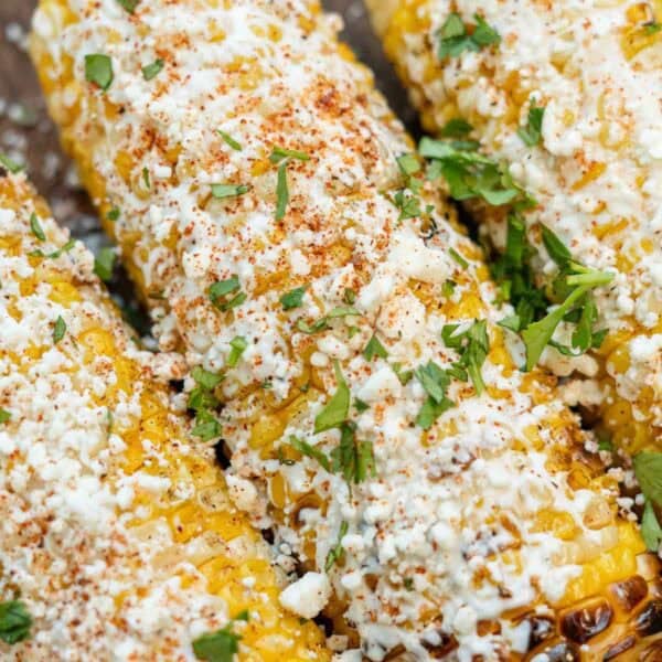 a close up shot of mexican street corn that was prepared on a grill