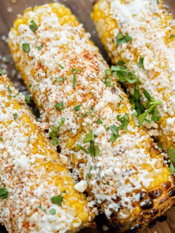 a close up shot of mexican street corn that was prepared on a grill