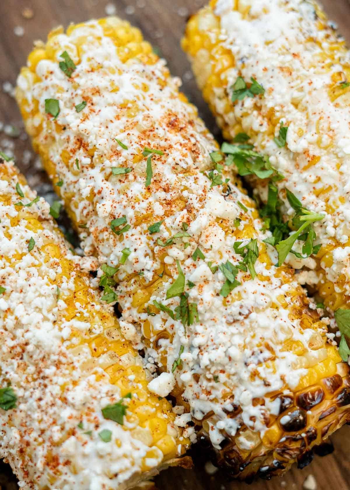 a close up shot of mexican street corn that was prepared on a grill