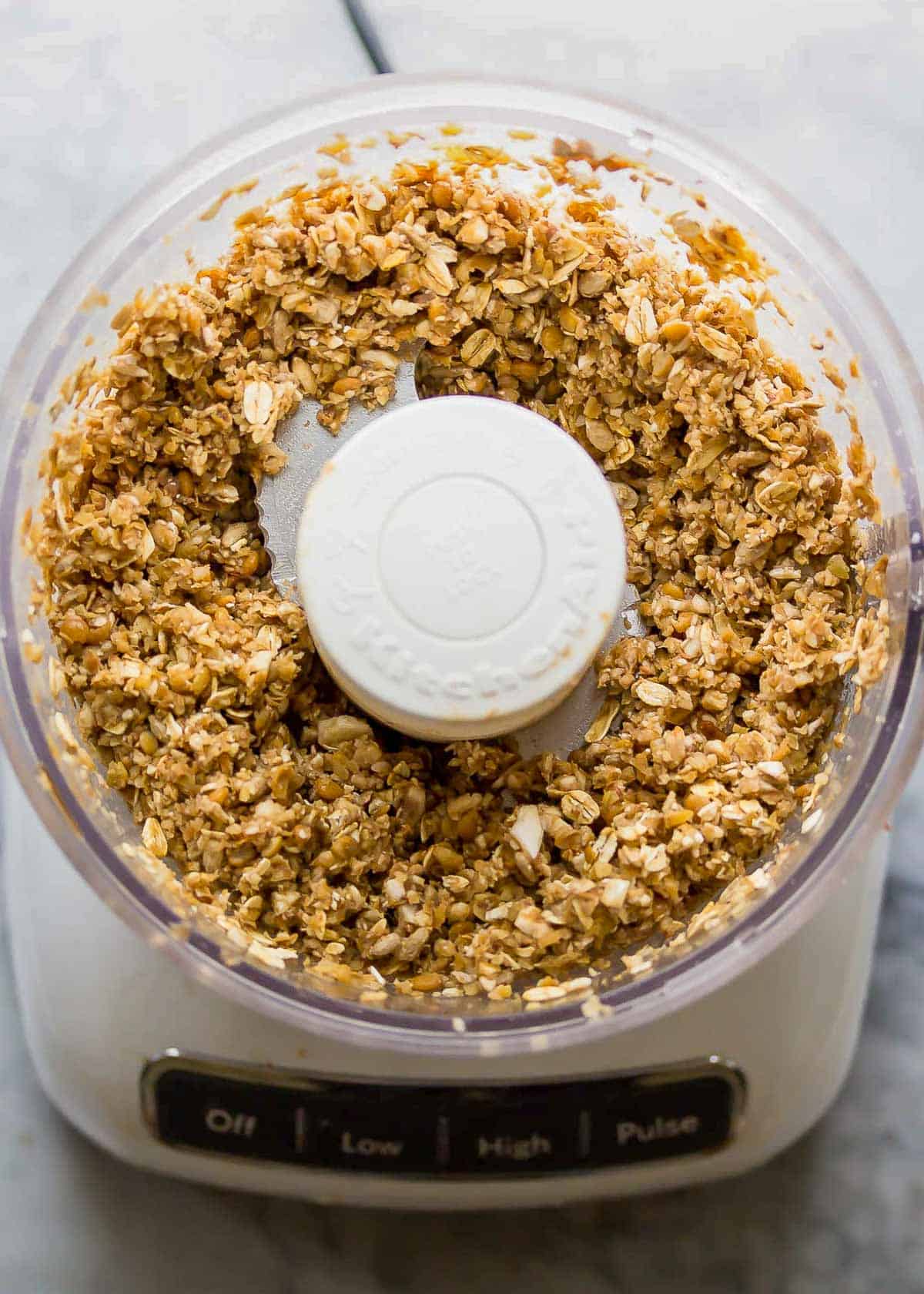 lentil burger mixture in a food processor with lentils, mushrooms, sunflower seeds, and oats.