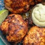 several air fryer boneless chicken thighs cooked to perfection with blackened seasoning, served with lime wedges and avocado crema