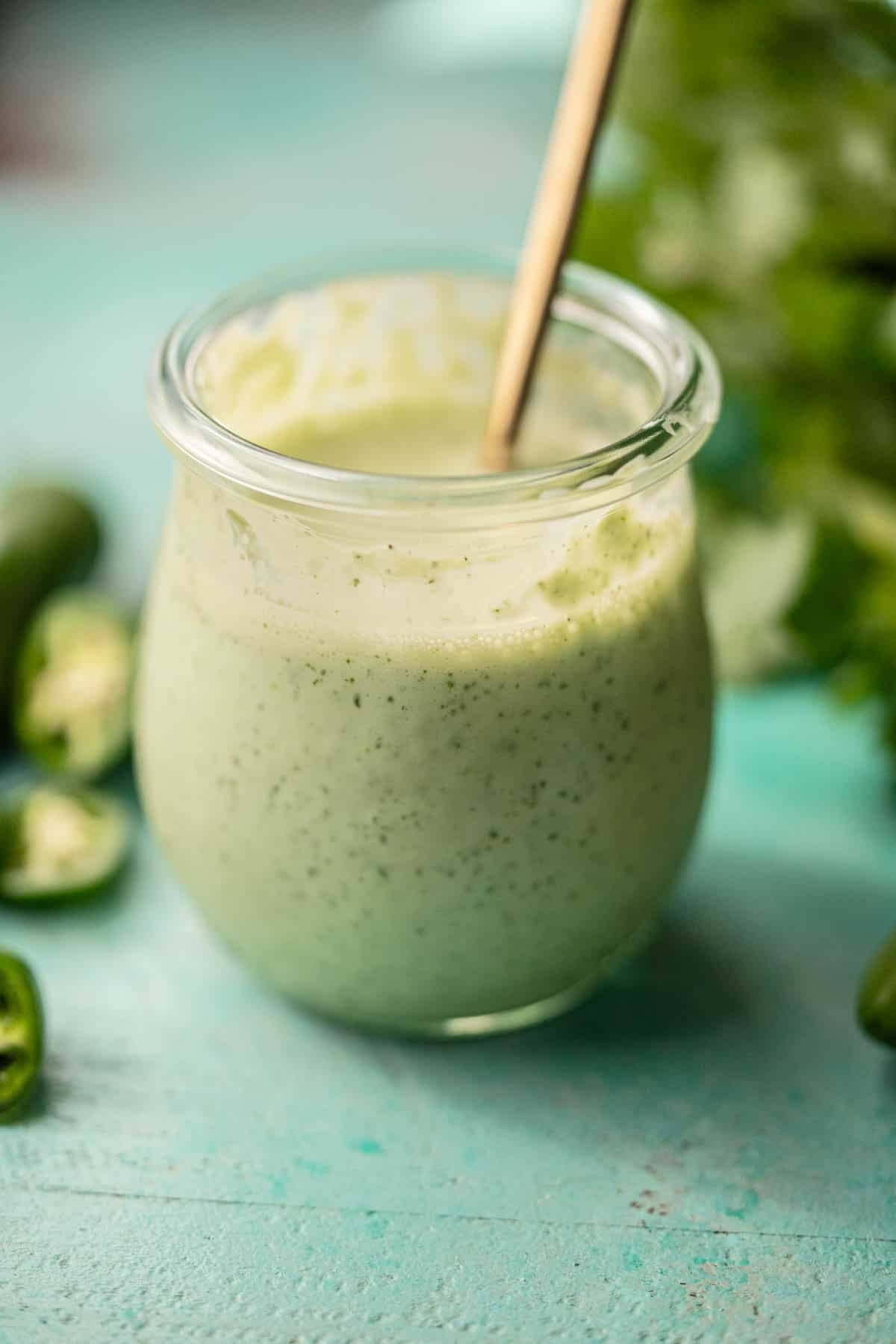 homemade salad dressing surrounded with jalapenos and cilantro