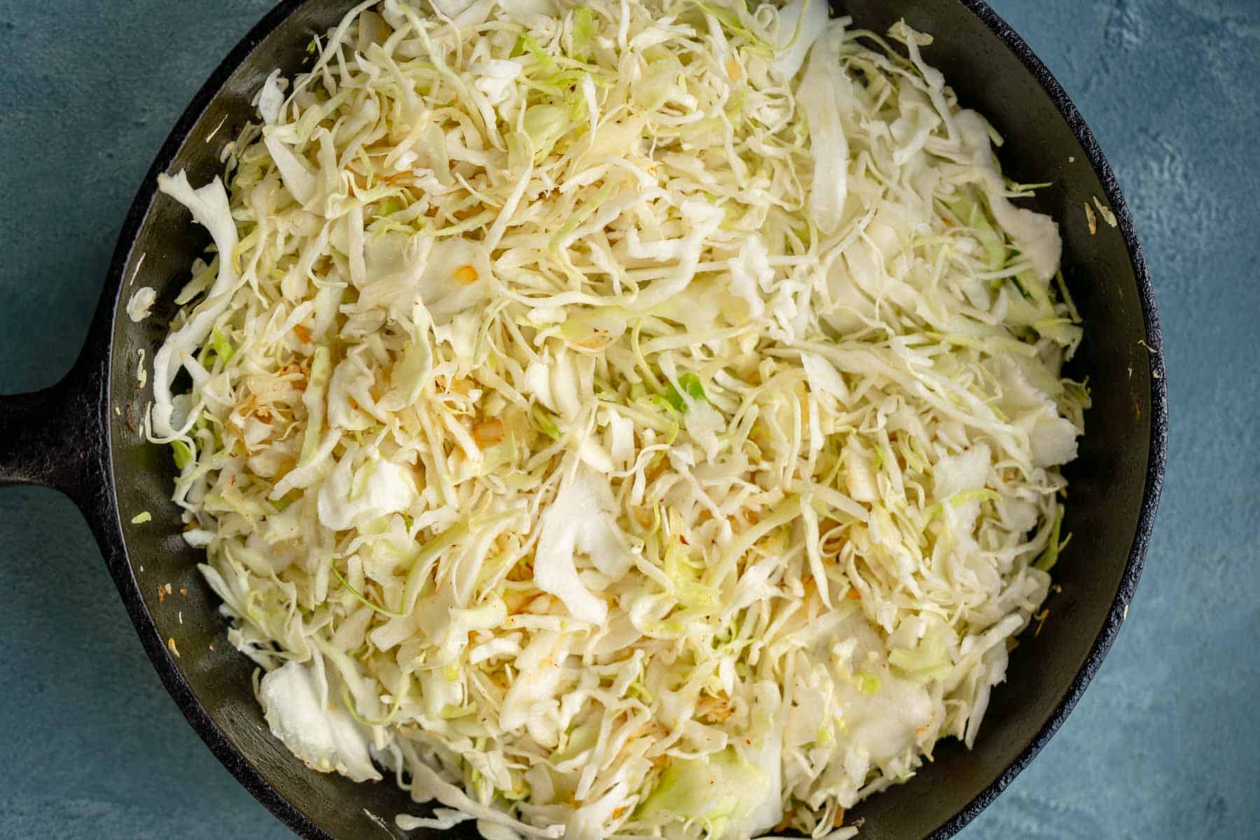 shredded cabbage dumped into a skillet