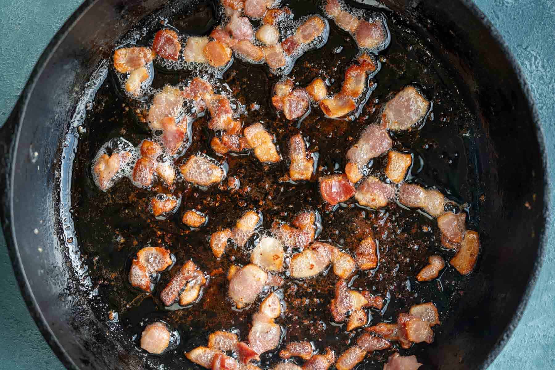 chopped bacon crisping up in a cast iron skillet