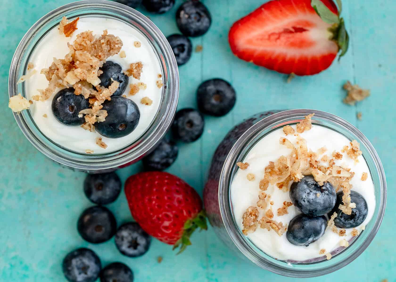 overhead shot showing two blueberry chia pudding parfaits topped with blueberries and granola