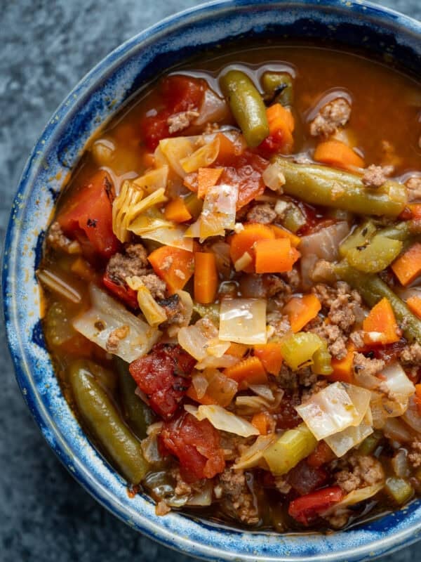 close up, overhead image of hamburger soup with cabbage in a blue bowl