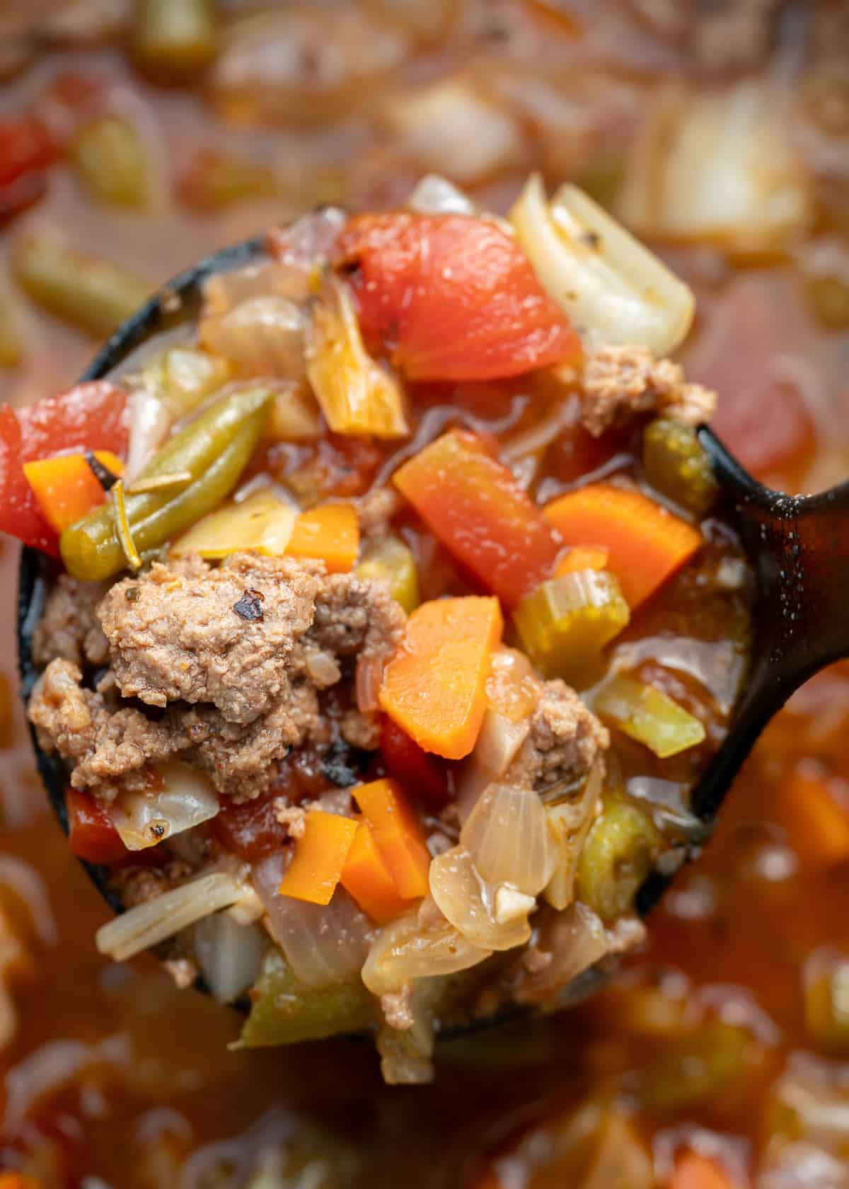 close up image of a spoonful of cooked cabbage soup with hamburger