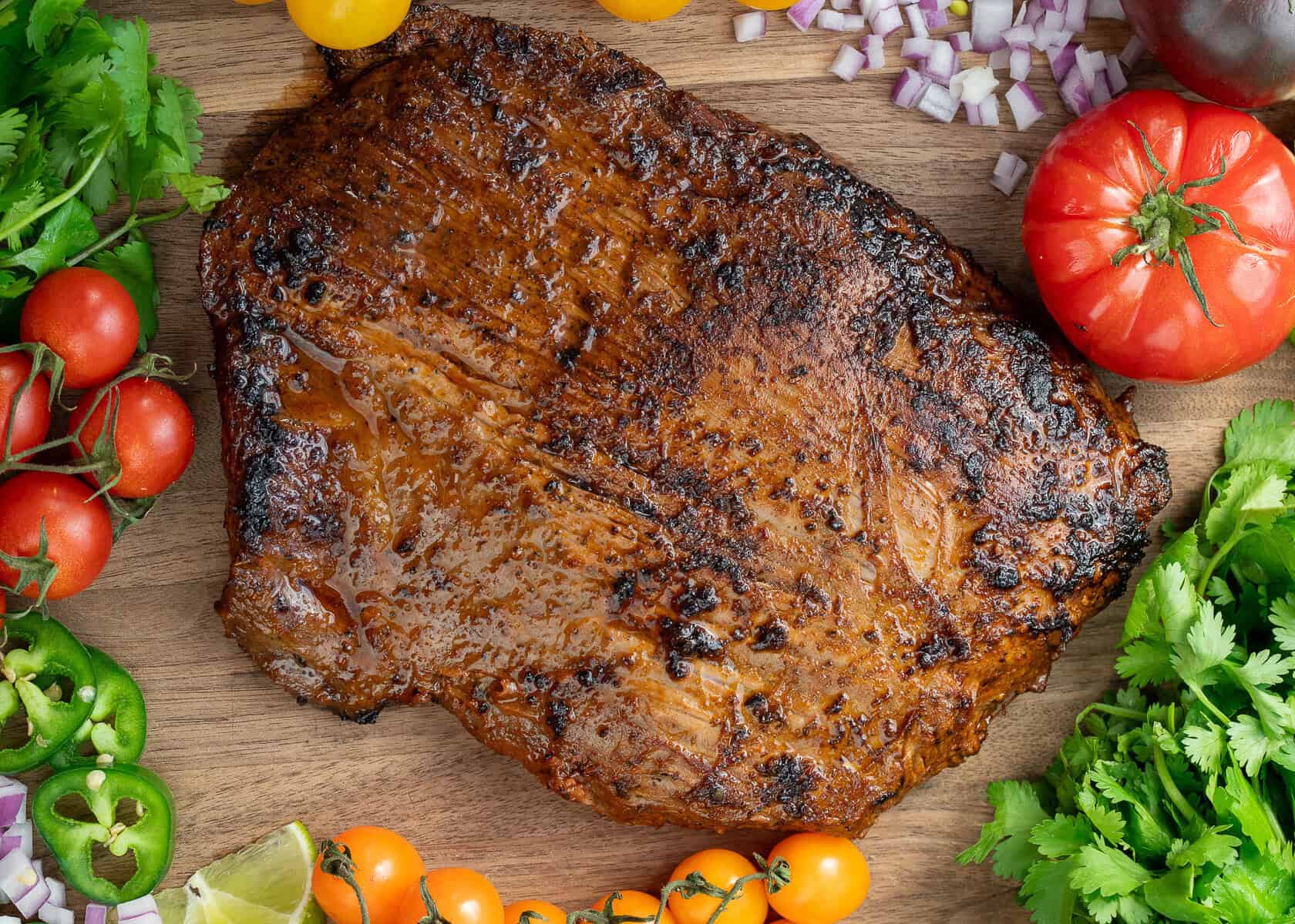a flank steak perfectly cooked with a great sear, resting on a countertop