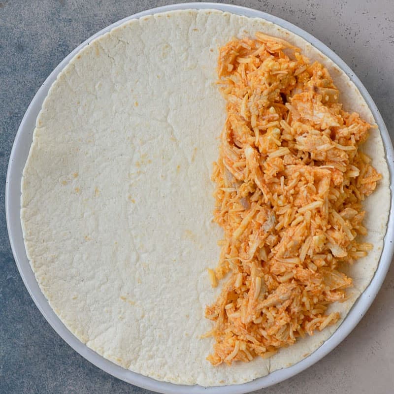 buffalo chicken on an open quesadilla on a white plate