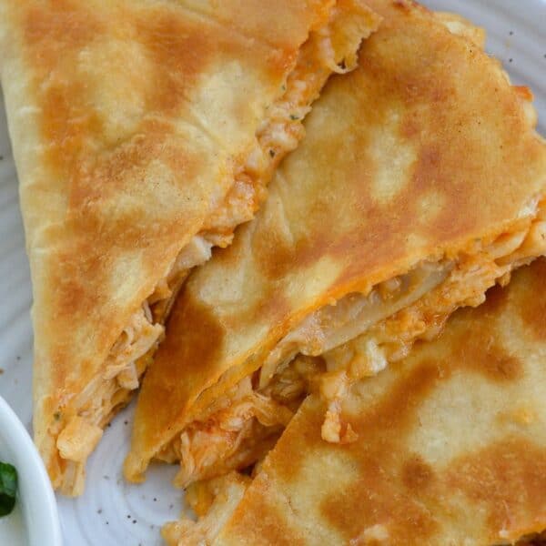 three slices of buffalo chicken quesadilla on a white plate