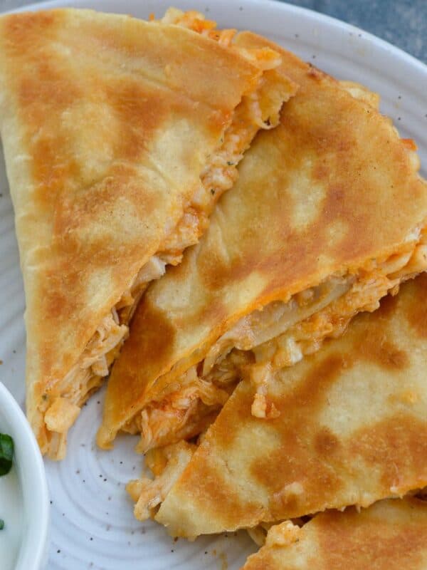 three slices of buffalo chicken quesadilla on a white plate