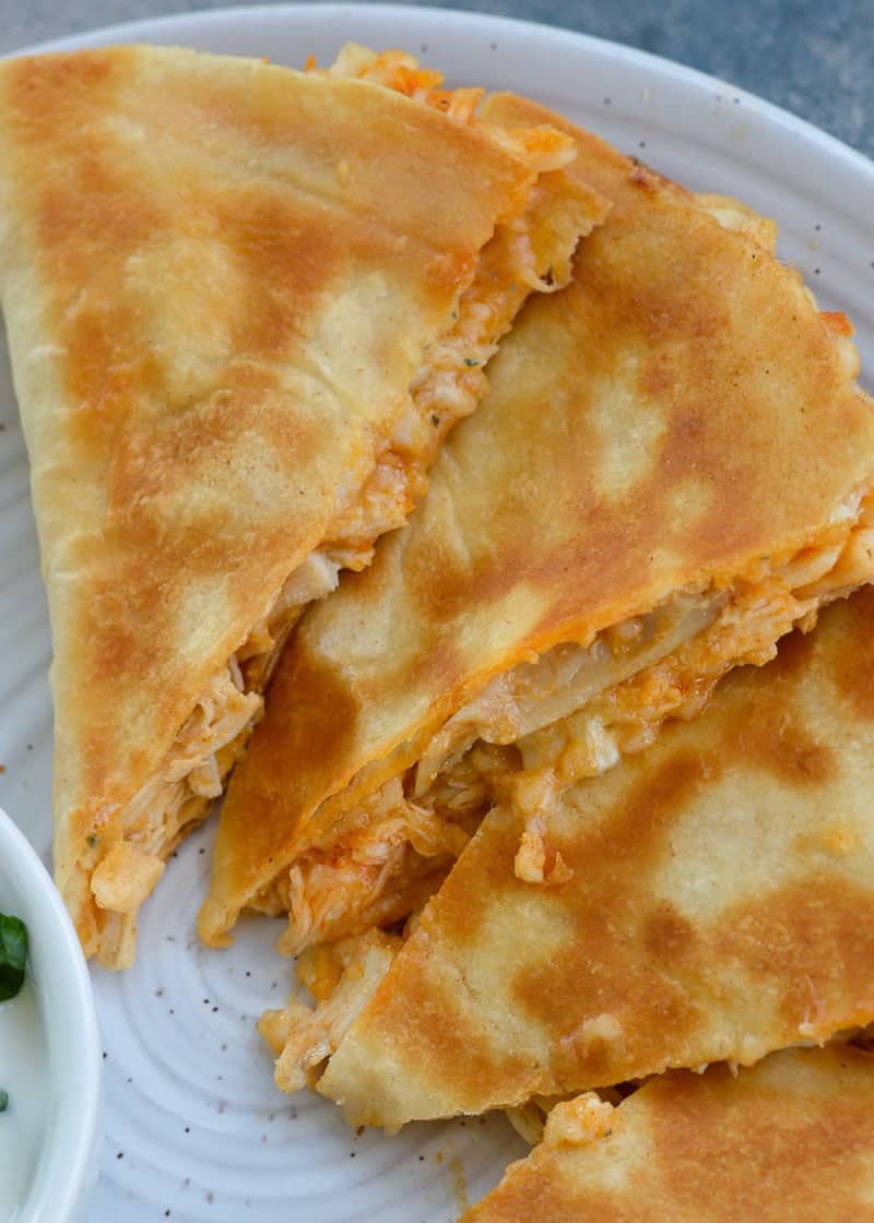 three slices of buffalo chicken quesadilla on a white plate