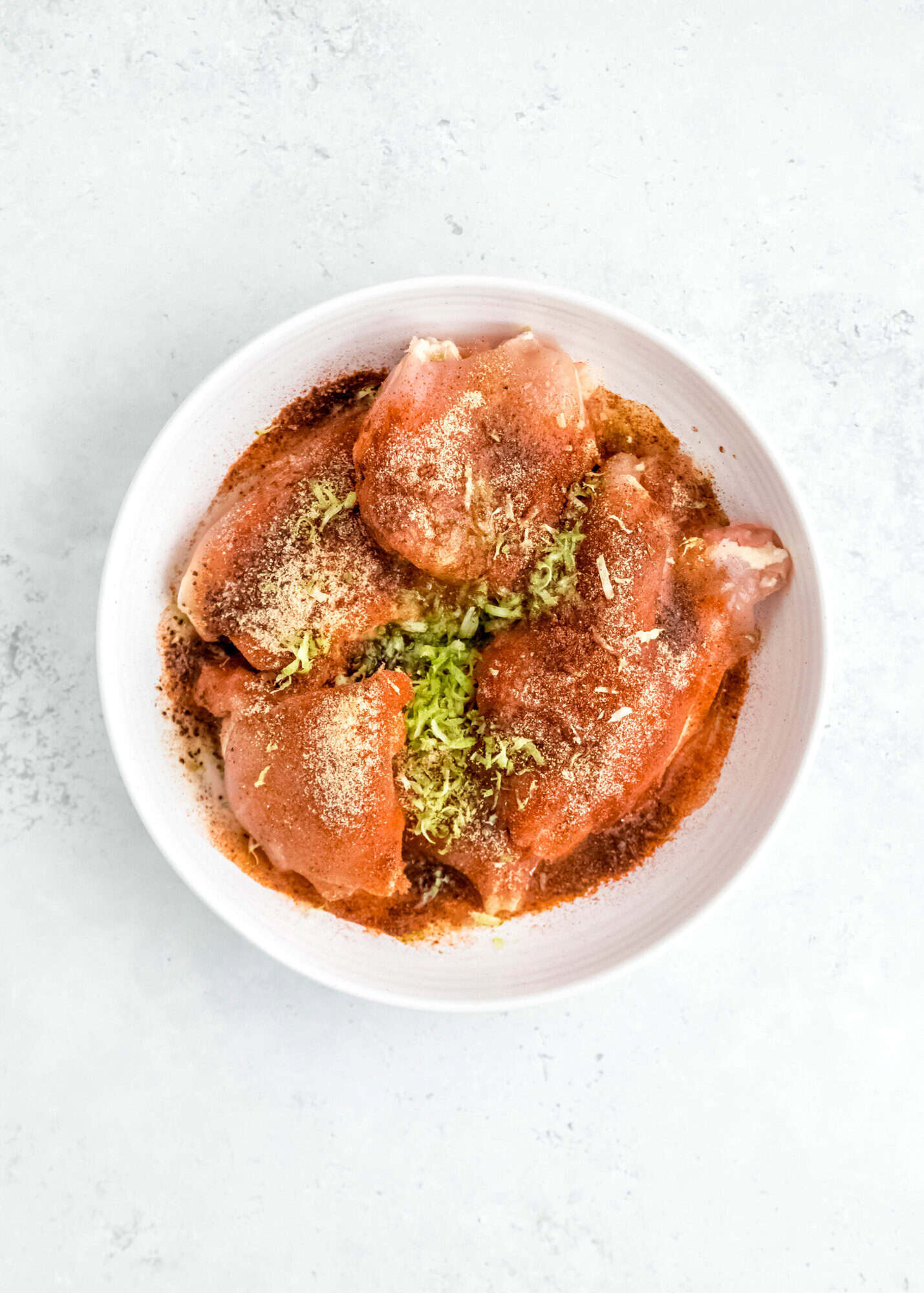 chicken thighs in a bowl with marinade for chicken tostadas